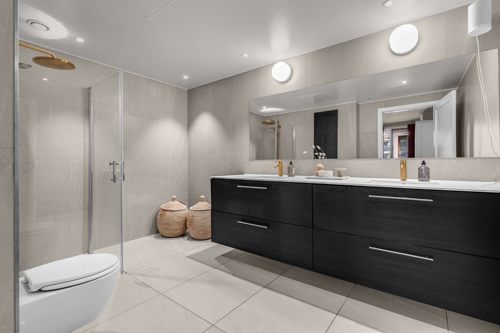 Delikat og innbydende bad en suite med dobbelservant, vegghengt klosett og stor dusjsone Galleribilde