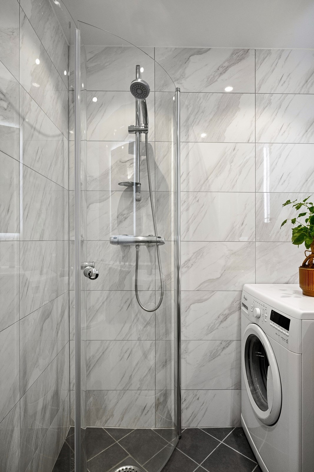 Videre har badet vegghengt toalett, dusjhjørne med buede svingdører og termostatstyrt blandebatteri. Det er også opplegg for vaskemaskin. Galleribilde