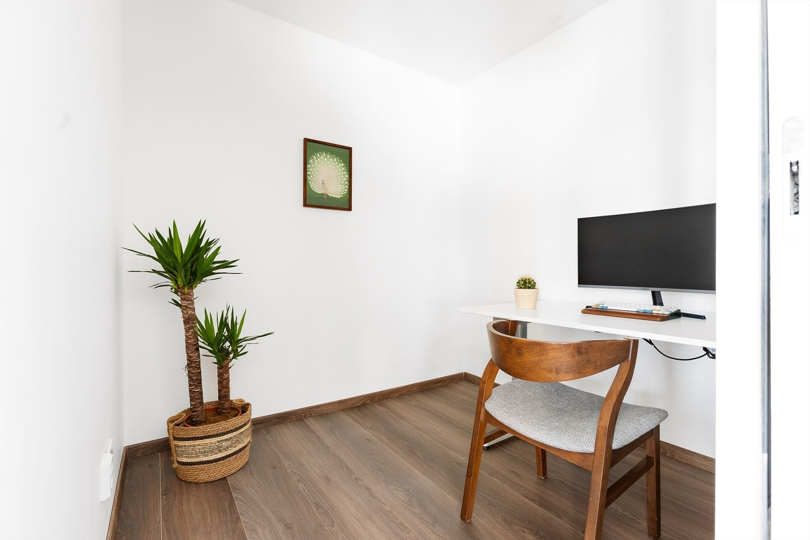 Kontor med adkomst fra stue med 1-stavs laminat og lysmalte veggflater. Plass til garderobeløsning og/- eller kontorpult Galleribilde