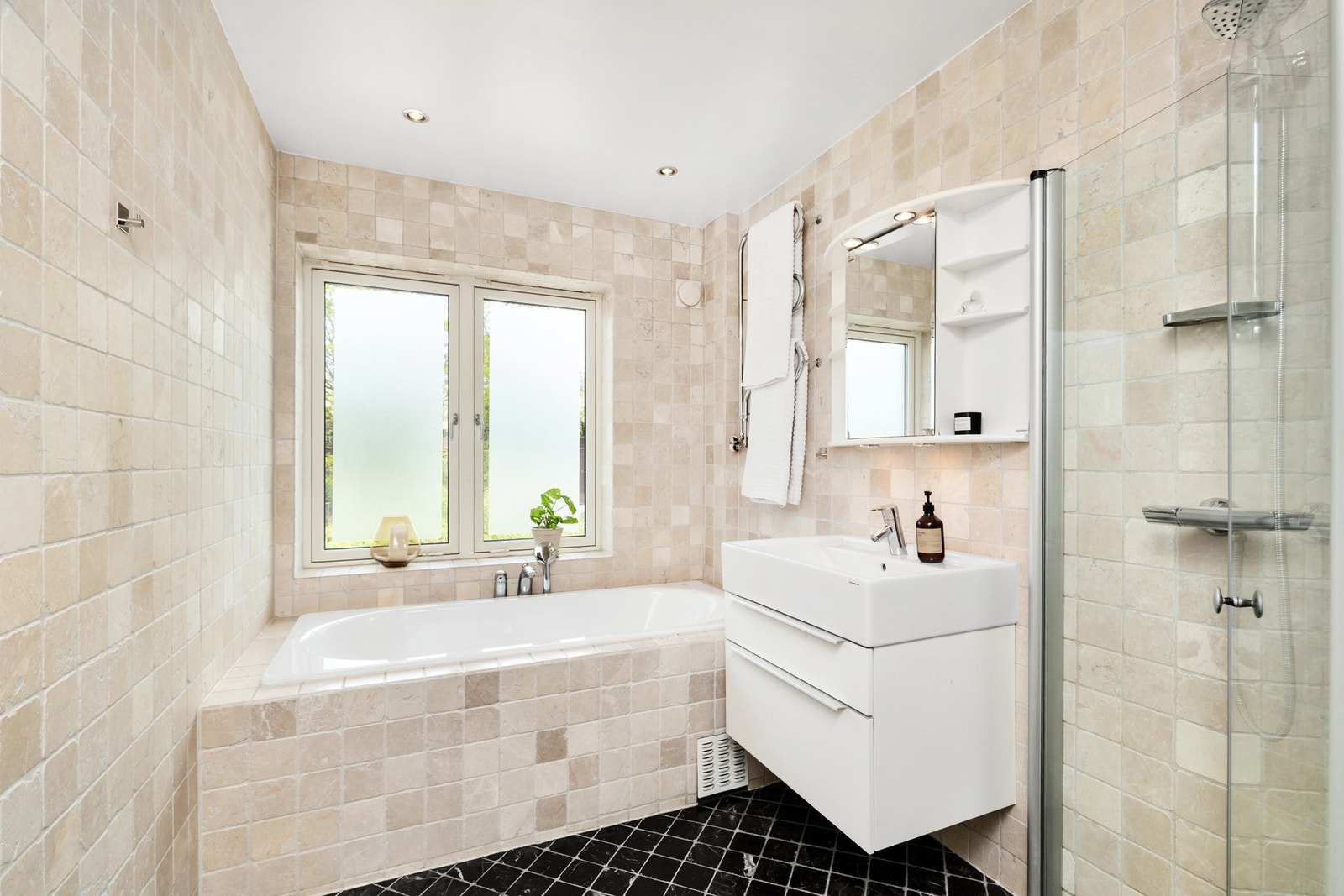 Flislagt baderom med gulvvarme. Badet har både dusj og badekar. Galleribilde