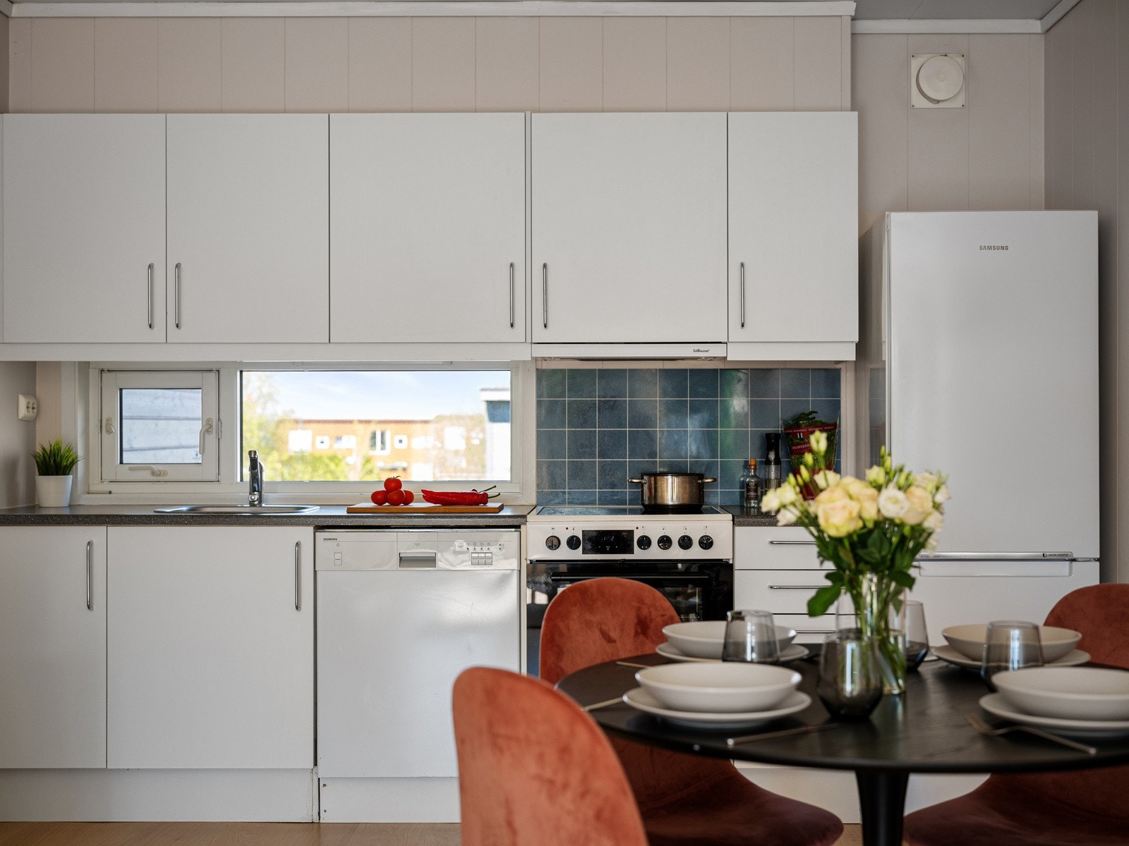 Lyst og pent kjøkken med hvitevarer Galleribilde