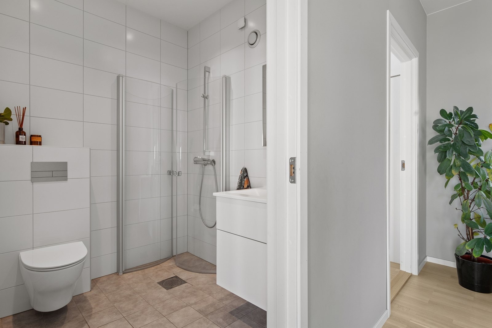 Baderommet har et lyst og tidløst uttrykk med flislagte overflater, gulvvarme og downlights i himling. Galleribilde