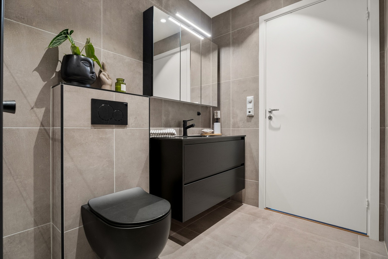 Sorte detaljer og innredning gir badet et eksklusivt og tidsriktig uttrykk. Galleribilde