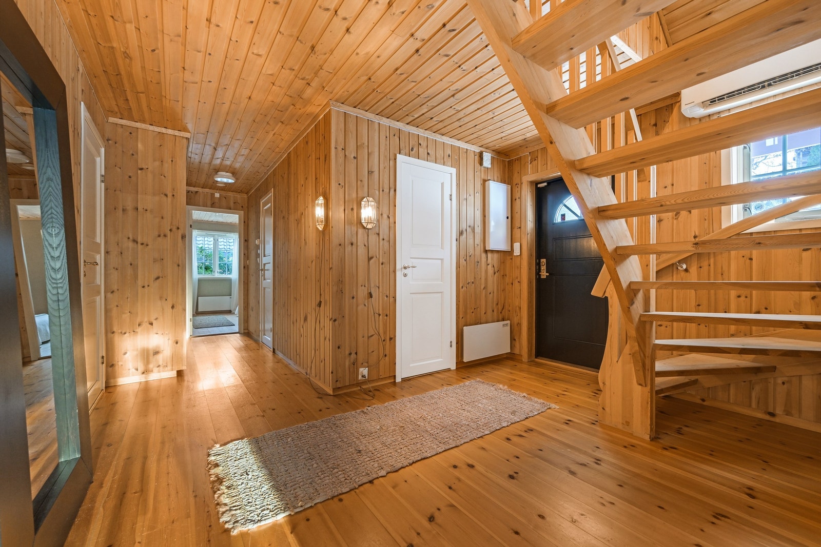 Romslig hall med trapp opp til 2.etg. toalettrom og stort garderobeskap i enden av gangen. Galleribilde