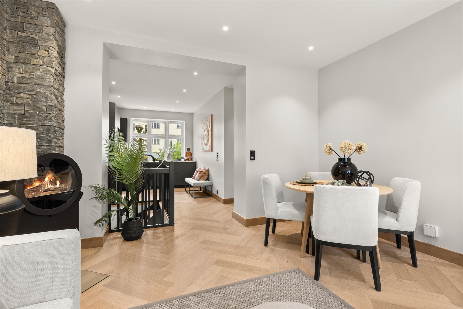 Den lette atmosfæren understrekes av lyse, glatte vegg- og takflater og en gjennomgående planløsning mot kjøkkenet i motsatt ende. Galleribilde