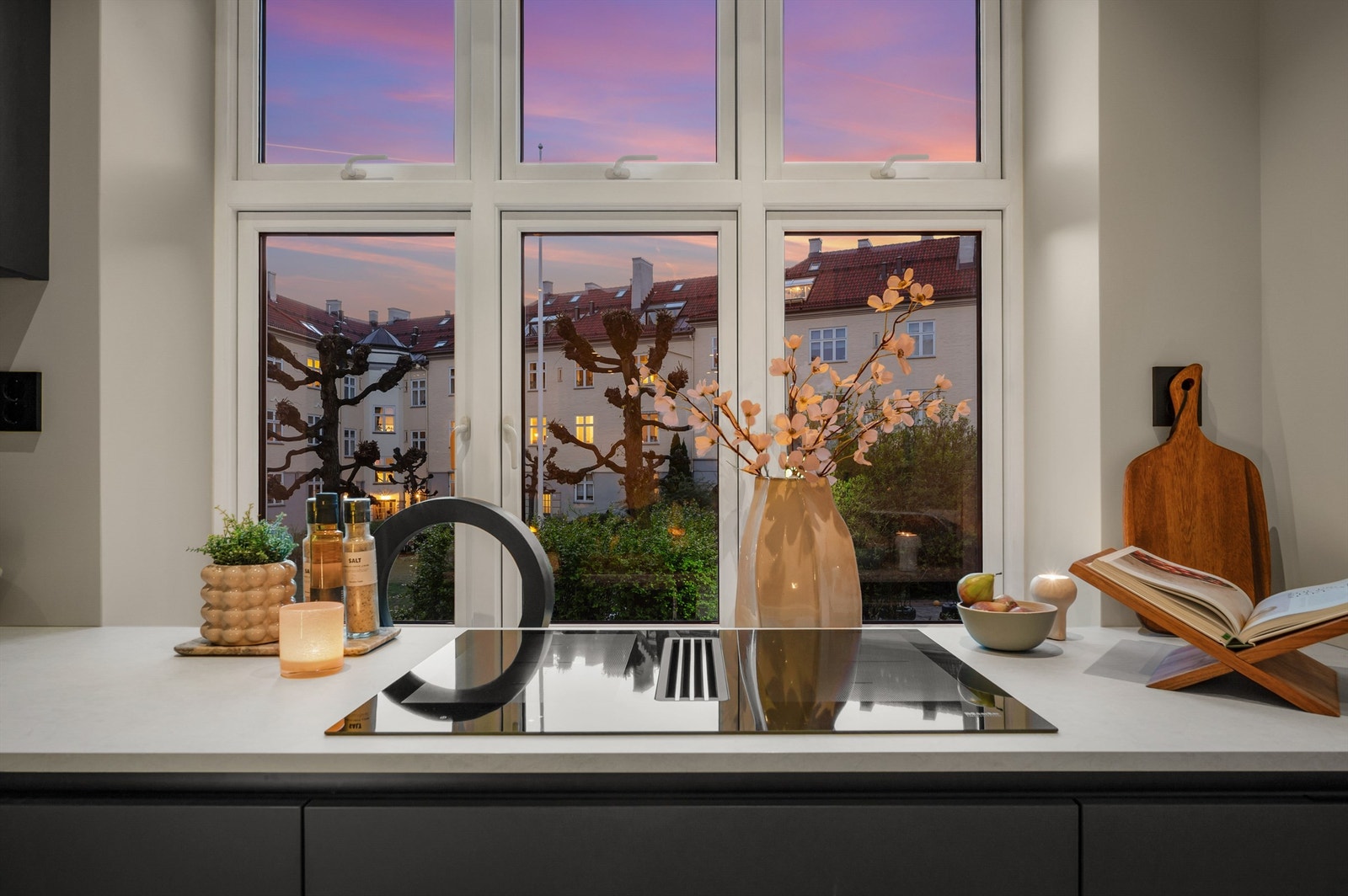 Et stort vindu over kjøkkenbenken vender ut mot en idyllisk bakgård, og det er downlight i himlingen og god benkebelysning, som sammen gir en ekstra lys og trivelig arbeidssone. Galleribilde