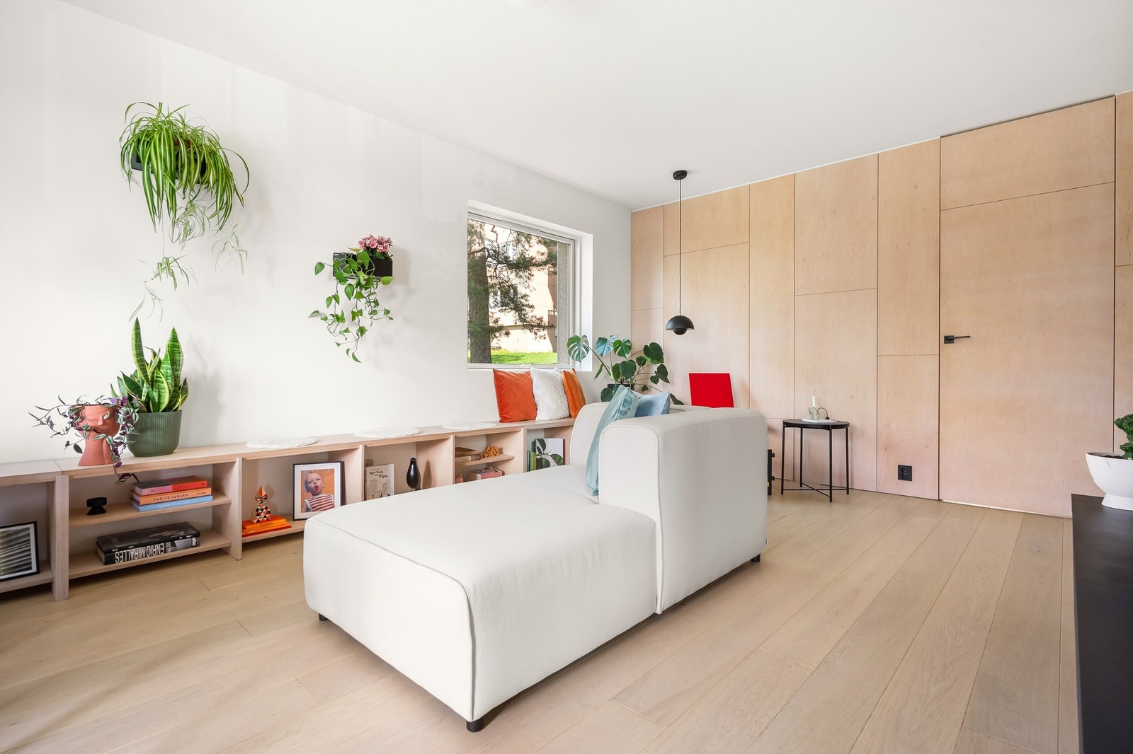 Stuen er romslig og fleksibel. Den er naturlig delt inn i tre soner: en hyggelig lesekrok ved vinduet, en sofagruppe med sjeselong som kan nytes fra to vinkler mot peisen, og en spiseplass. Galleribilde