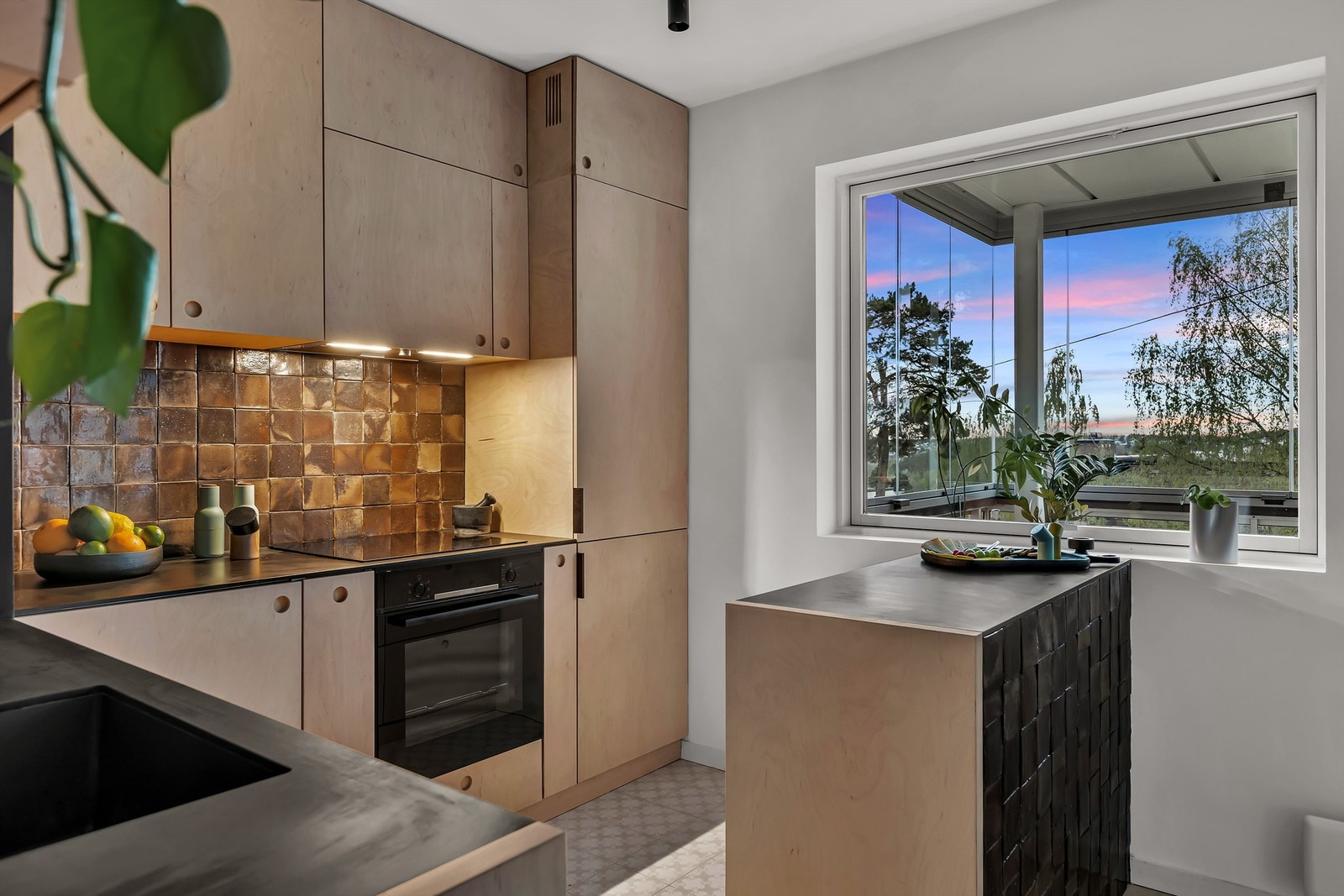 Mellom kjøkkenbenk og overskap er det flislagt, samt stikkontakter under overskapene. Galleribilde