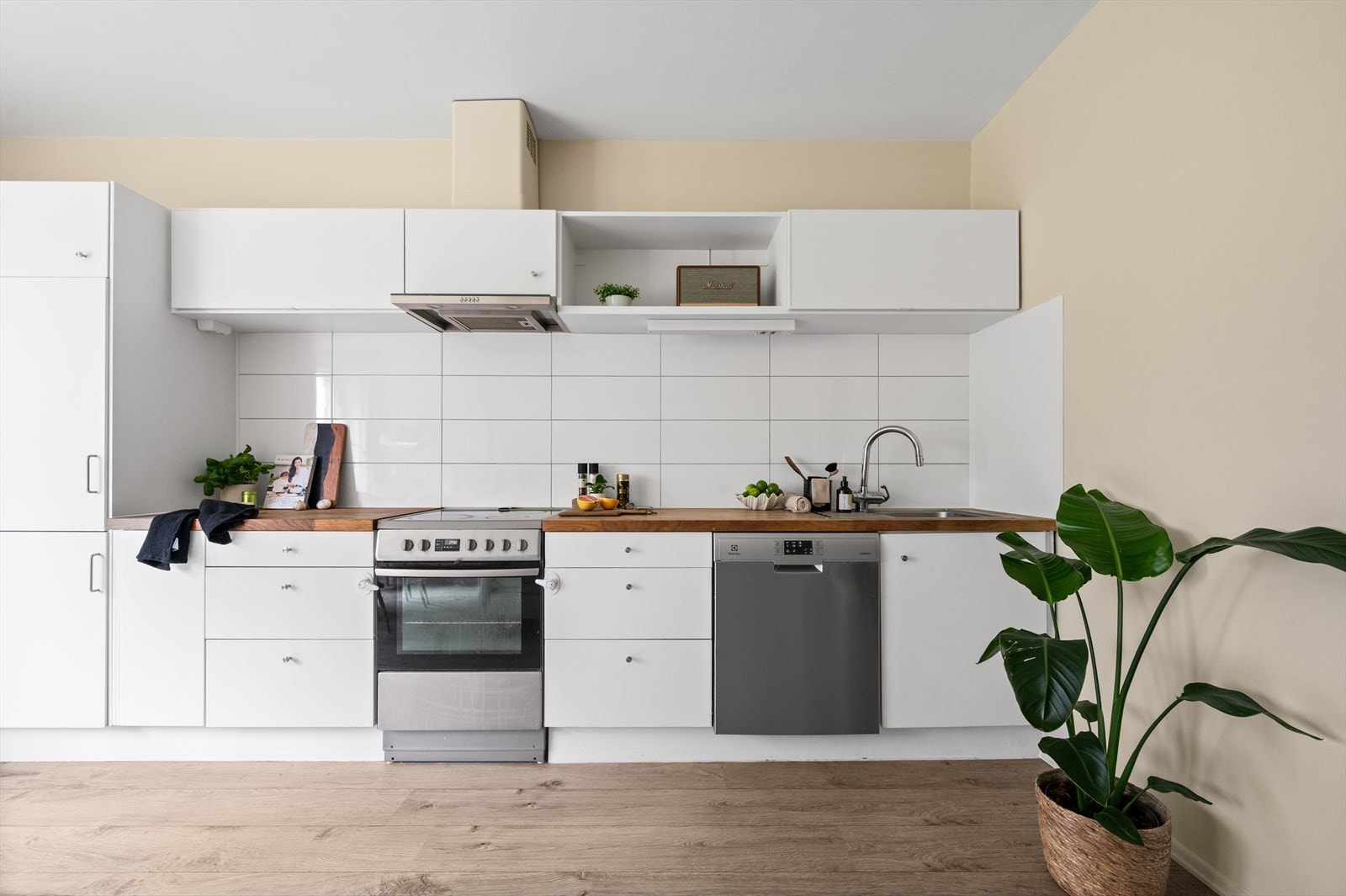 Stilren kjøkkeninnredning med lyse fronter og heltre benkeplate. Innredningen er fra 2008, oppgradert med overflatebehandling av skapfronter i 2022 og ny benkeplate i 2020. Galleribilde