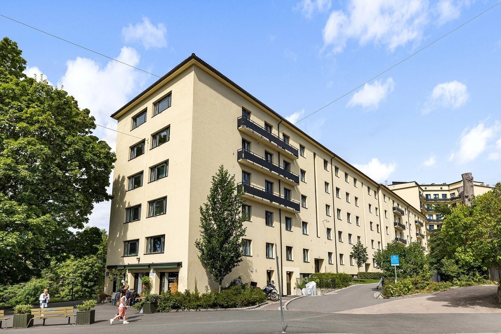 Borettslaget har en flott beliggenhet midt mellom grønne lunger og det urbane bylivet. Sommerbilde av gården. Galleribilde