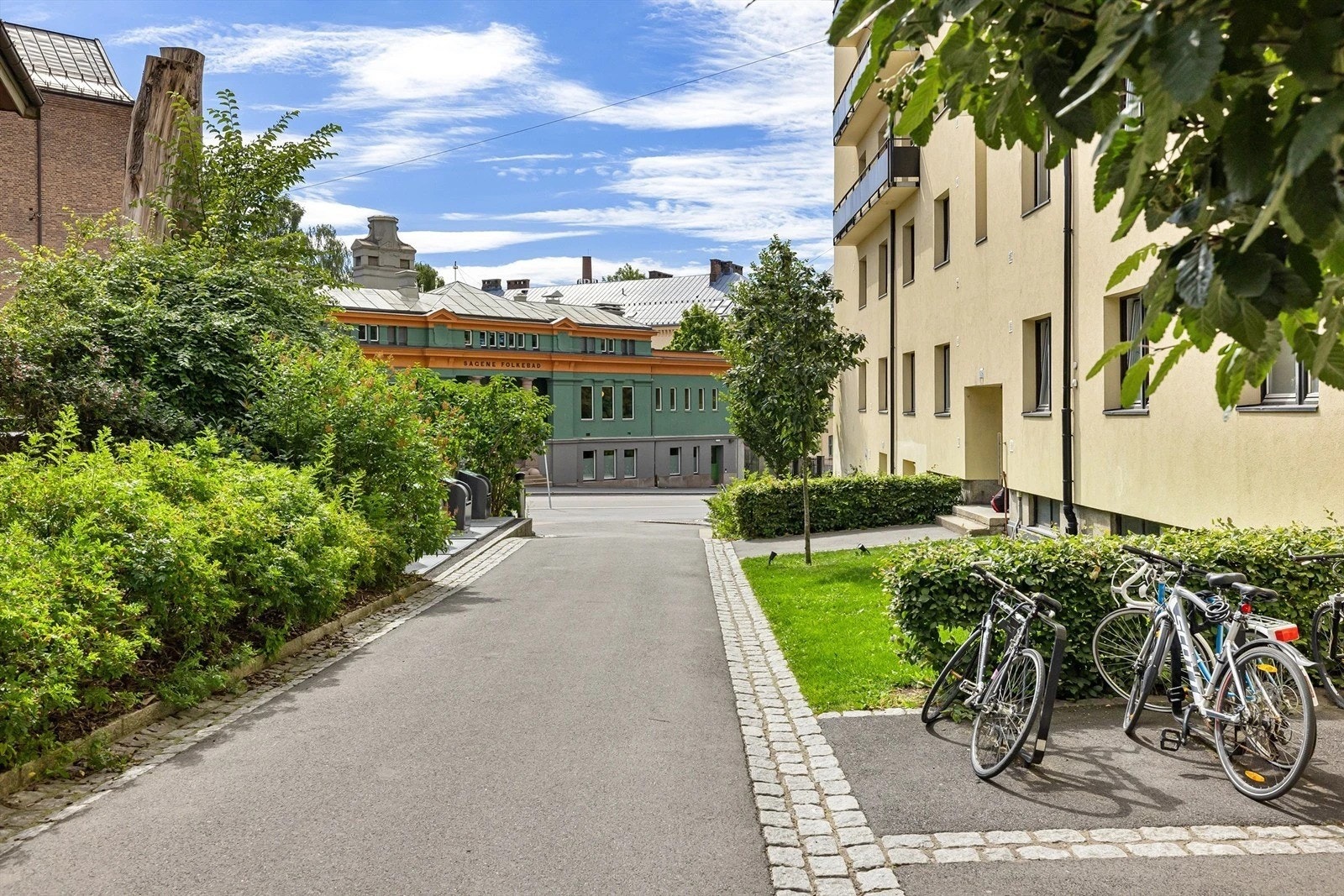 Borettslaget kan tilby bruk av fellesvaskeri og hobbyrom for beboerne. Sommerbilde av gården. Galleribilde