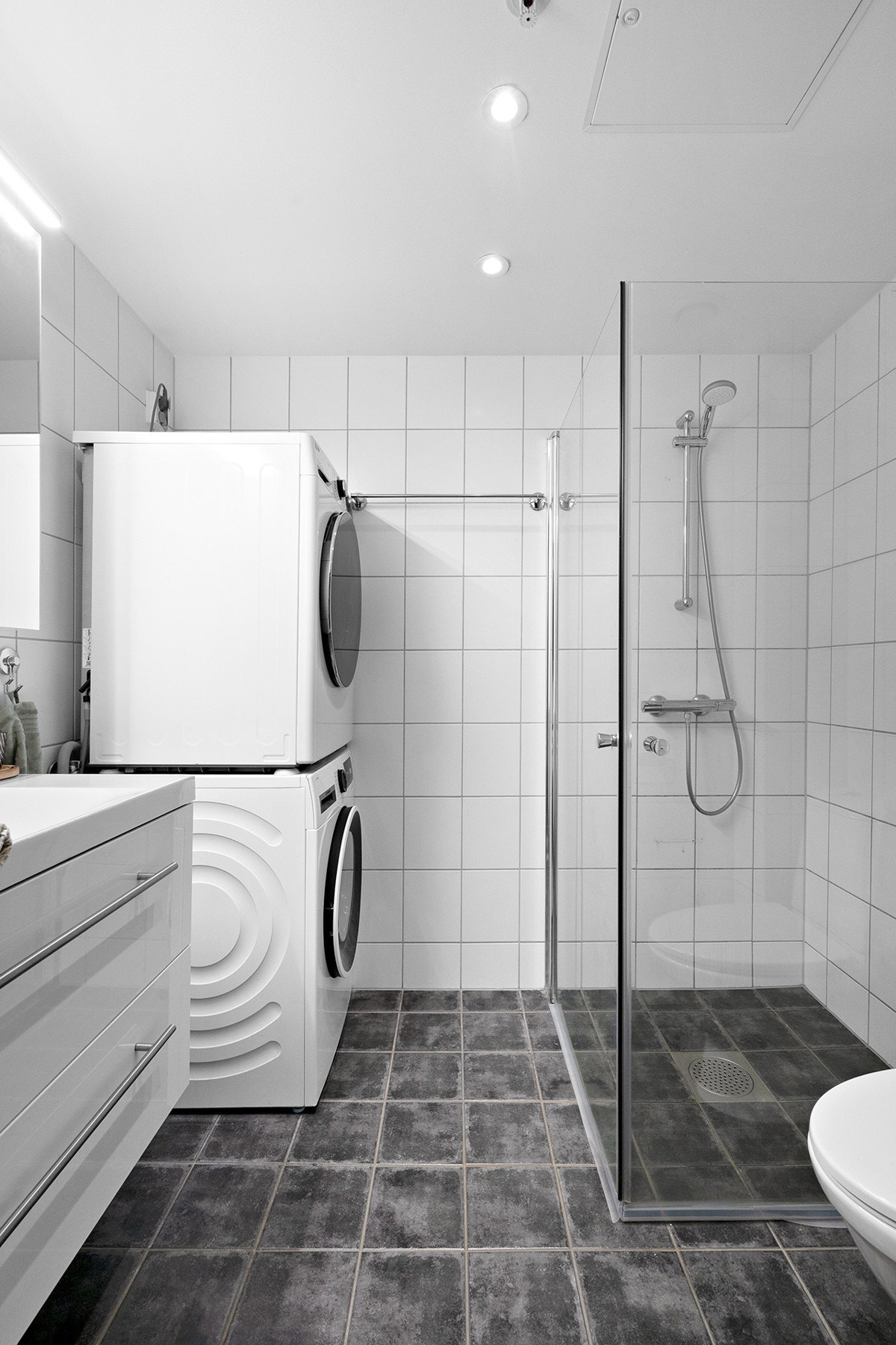 Flislagt bad med varme i gulv og dusjhjørne med svingbare dører. Badet har opplegg for vaskemaskin Galleribilde