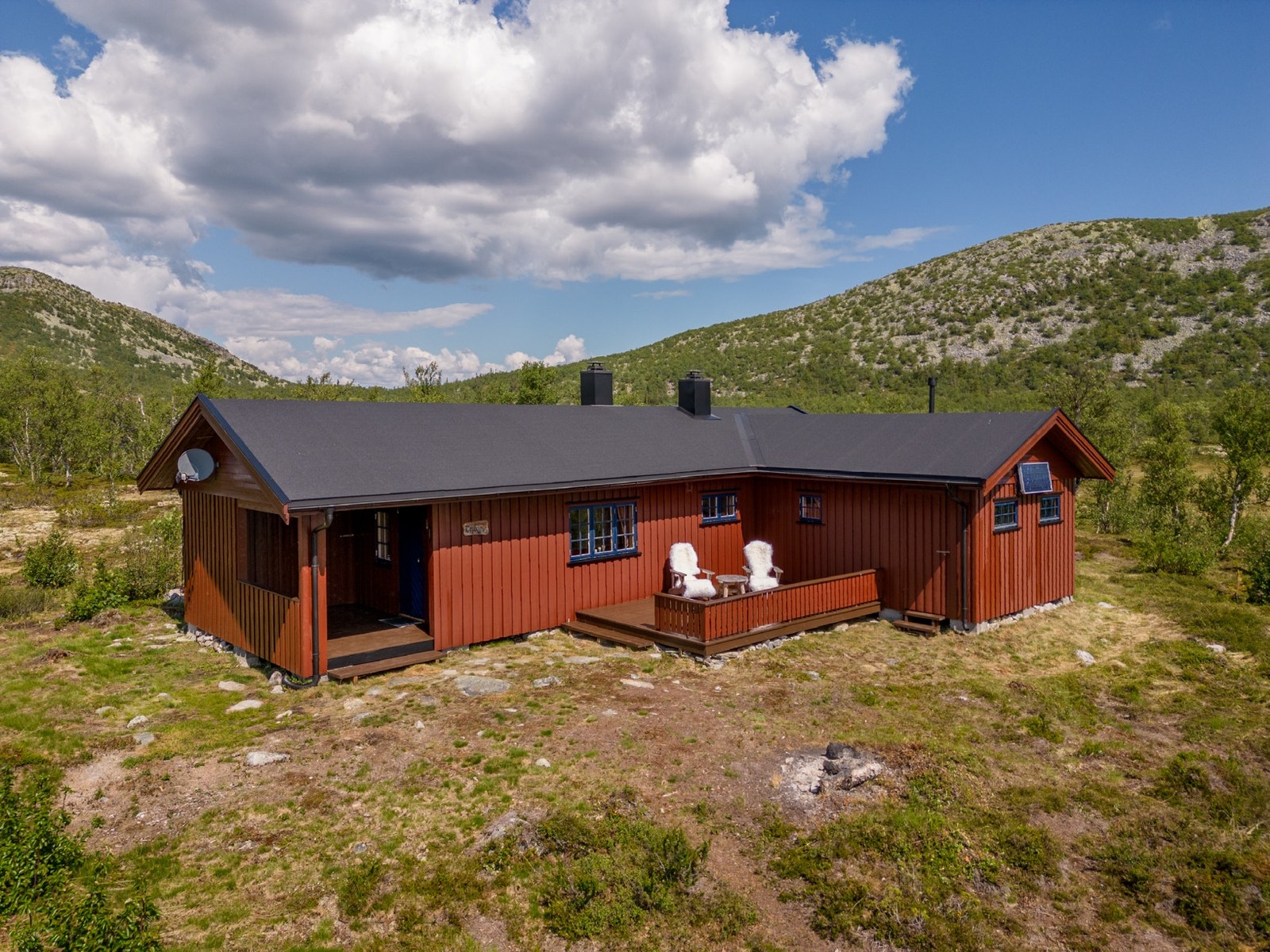 Stor vinkelhytte med overbygd terrasse og terrasse i lun krok. Galleribilde