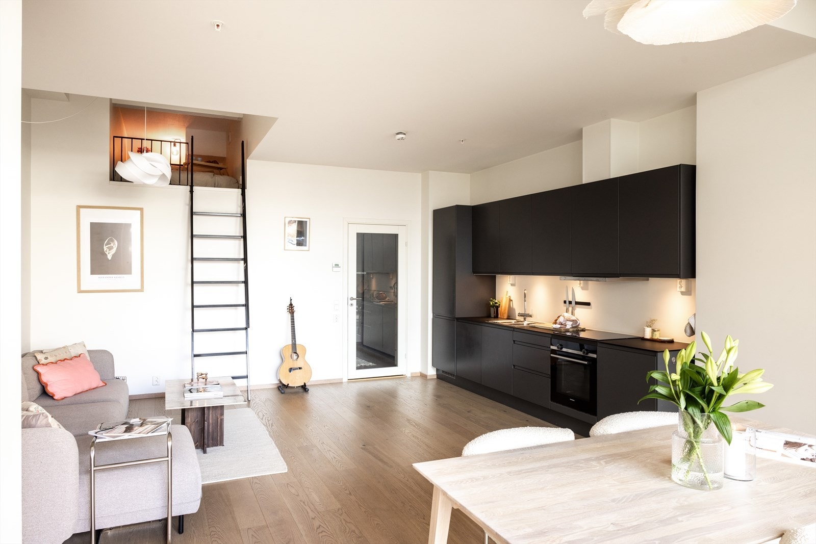 Stilrent kjøkken i åpen løsning mot stue - noe som skaper en sosial atmosfære. Galleribilde