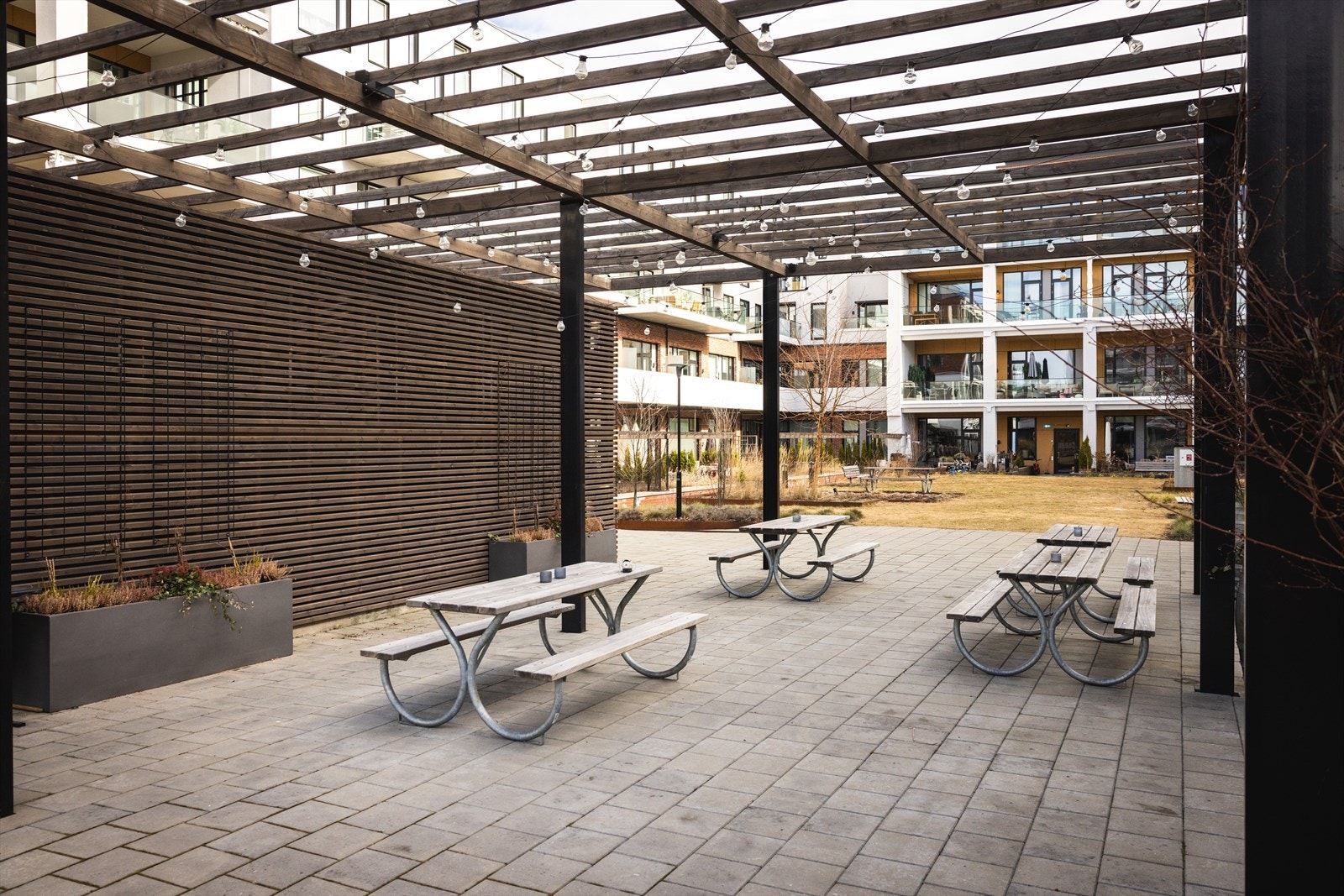 Hyggelig bakgård med sittegrupper og beplantning. Galleribilde