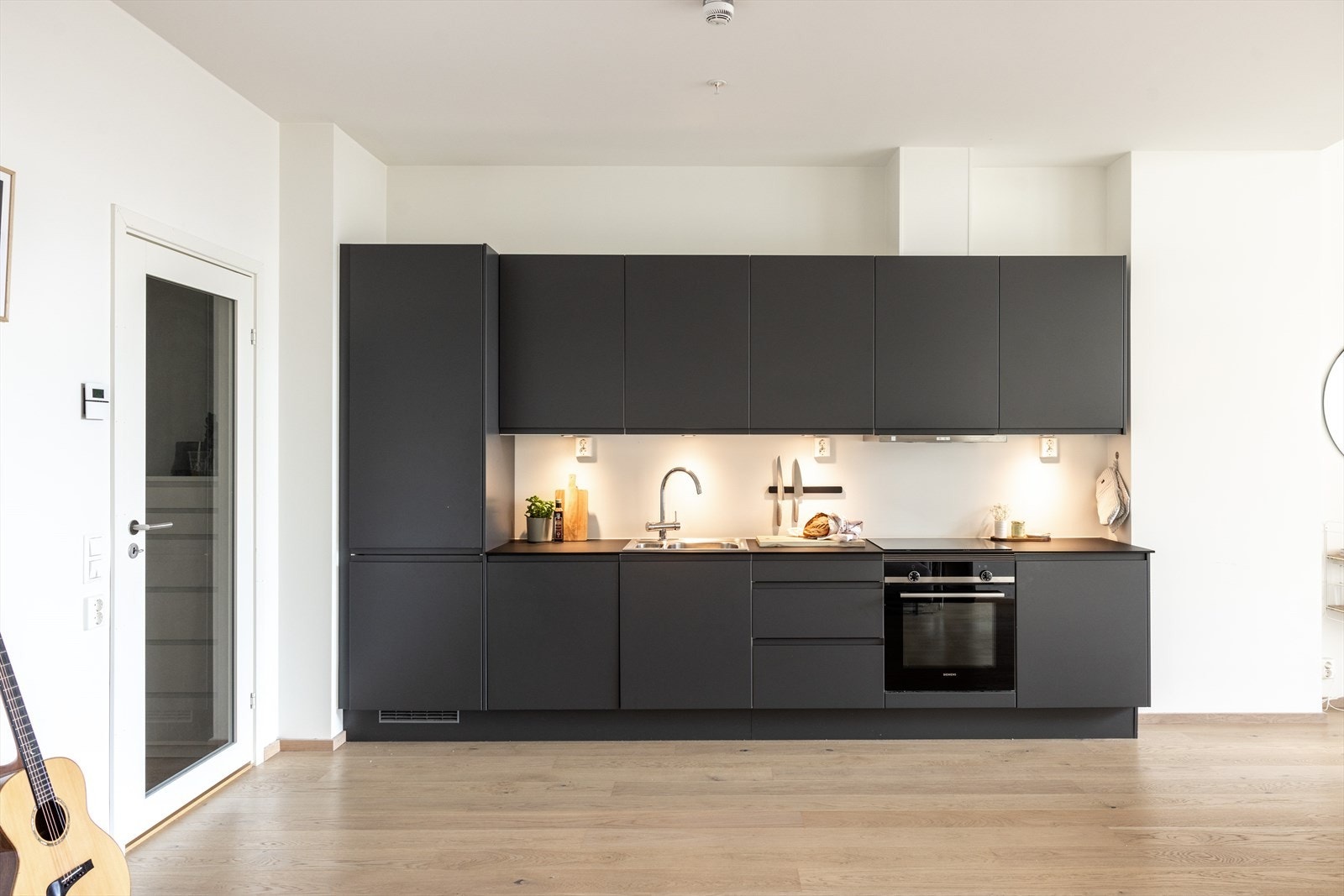 Kjøkkeninnredningen består av sorte glatte fronter, med benkeplate av laminat og nedfelt vaskekum. Galleribilde