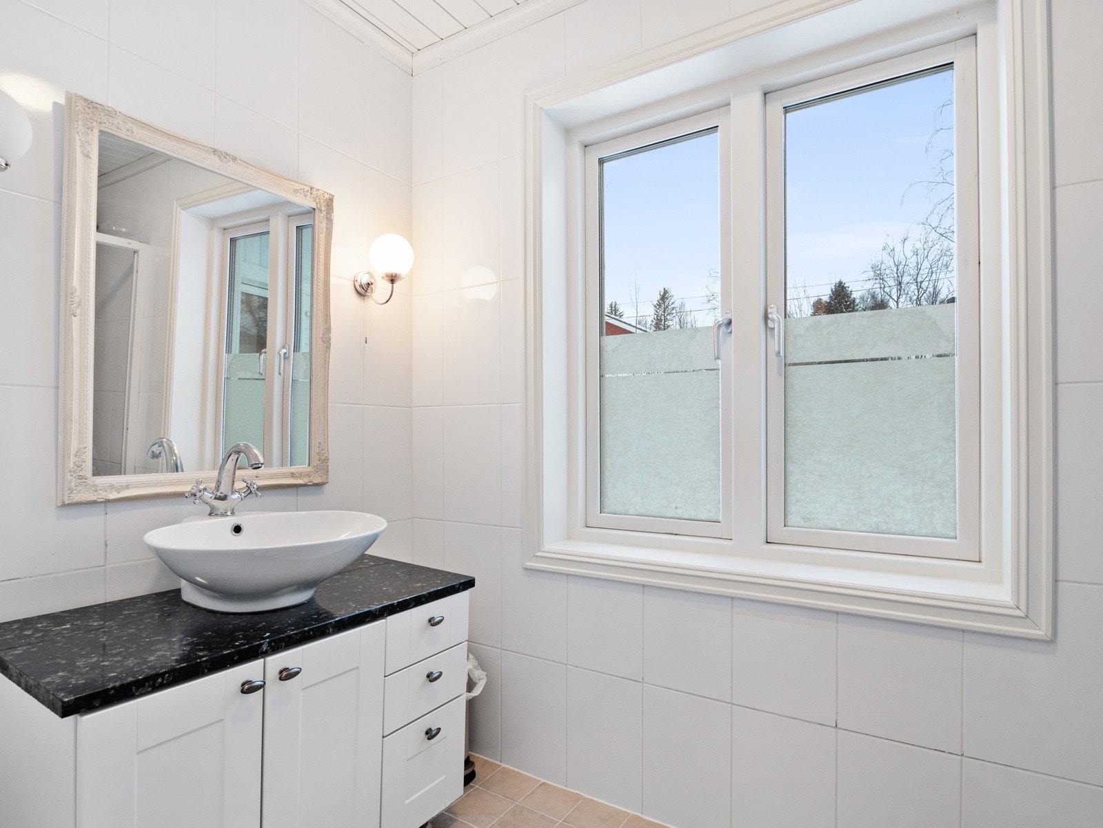 Badet i hovedetasjen er lite, med pen servant, innredning og dusjnisje Galleribilde