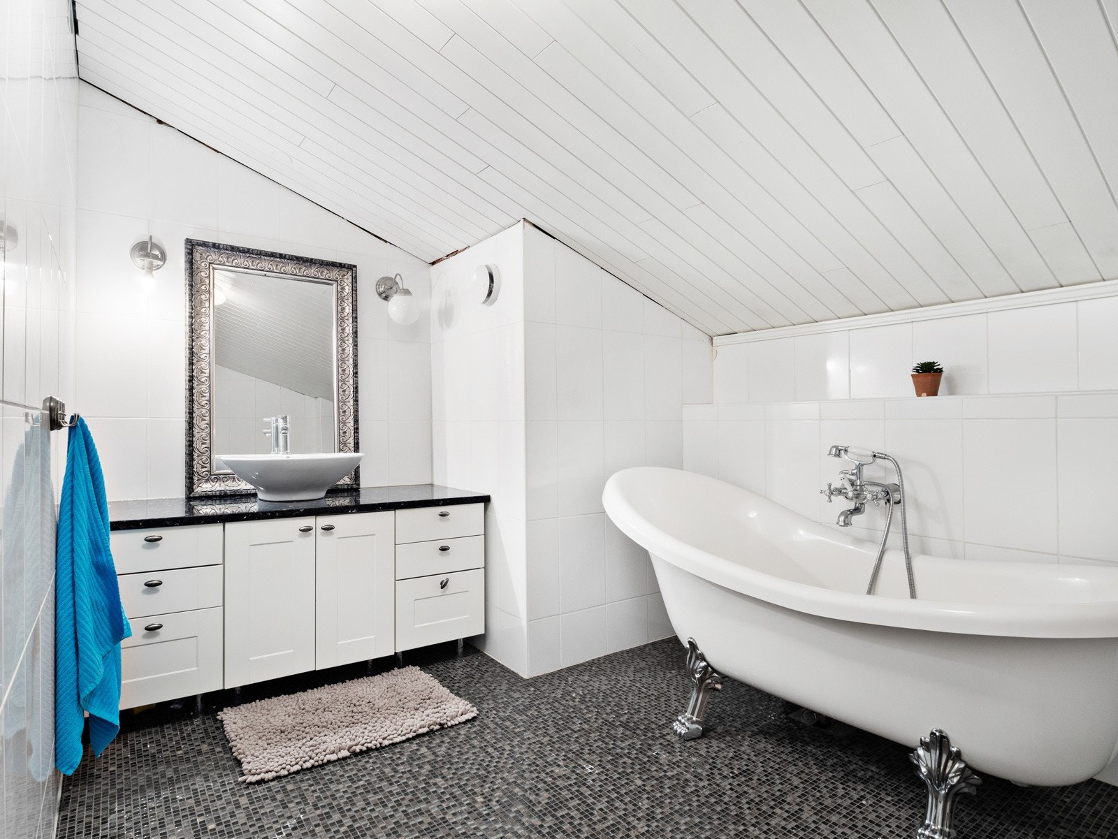 Baderommet i andre etasje har stor innredning og stilig badekar Galleribilde