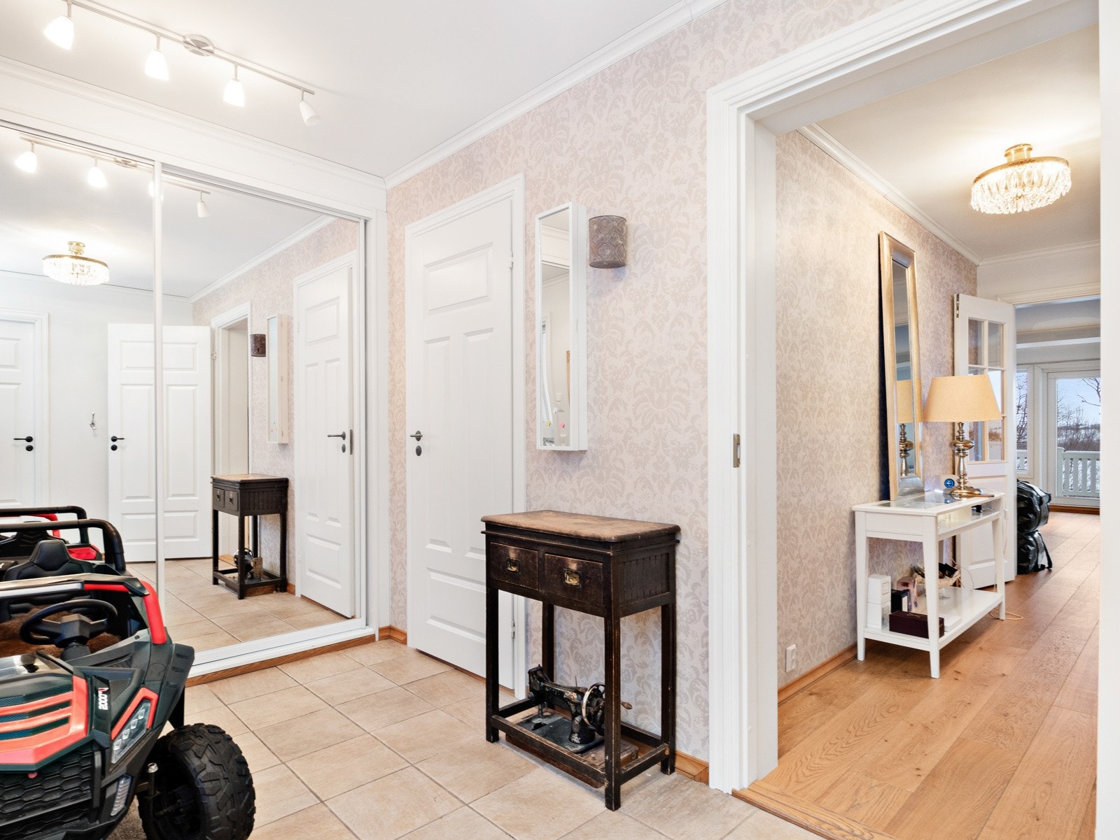 Hallen sett mot stuen, med skyvedørsgarderobe og inngang til vaskerom til venstre i bildet Galleribilde