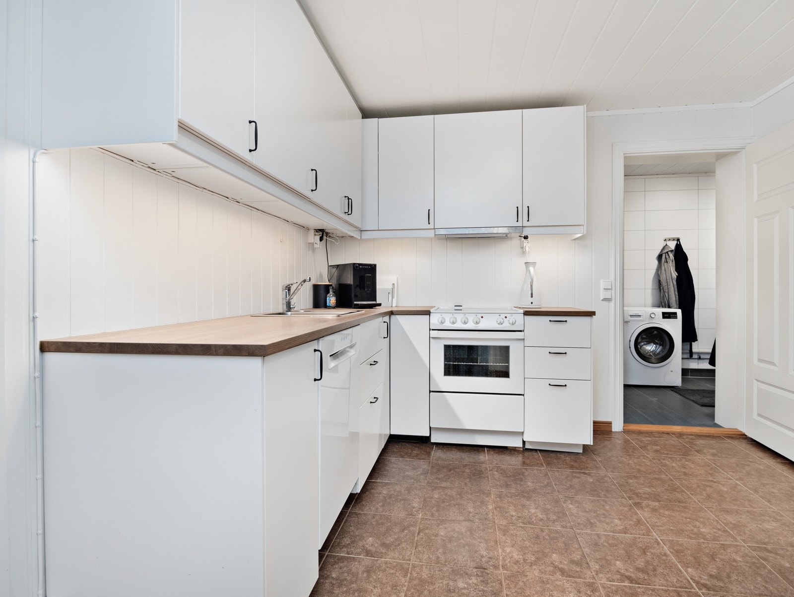 Kjøkkenet er lyst og romslig, med masse oppbevaringsplass Galleribilde