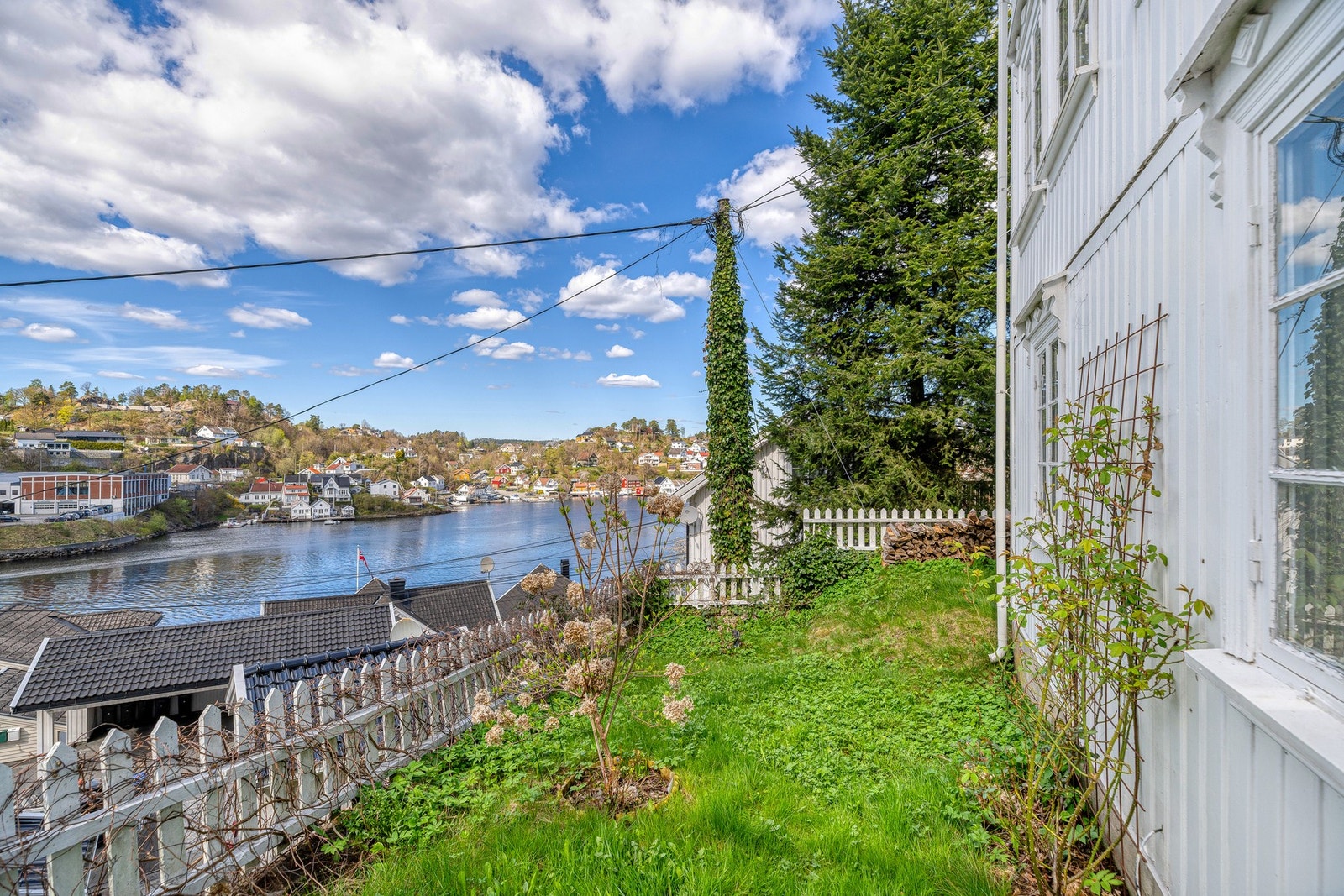 Rundt en liten, nordvestvendt hage er det hvitt stakittgjerde. Galleribilde