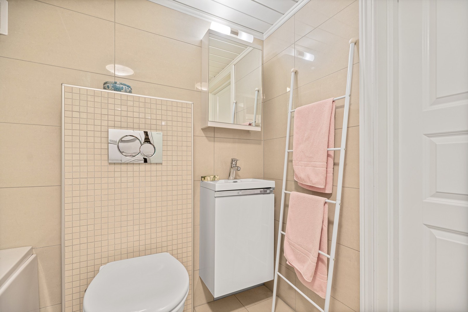 Ved tv-stuen i underetasjen er det et pent, helfliset bad med badekar og vegghengt toalett. Galleribilde