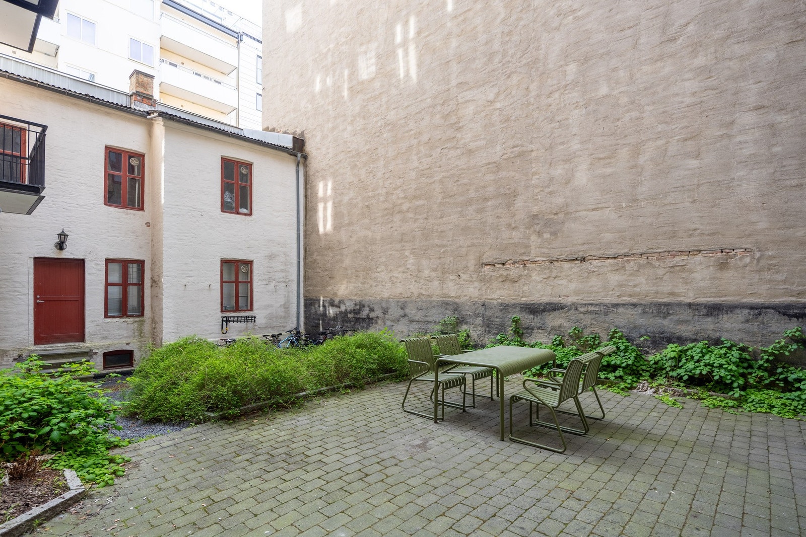 Bakgården er opparbeidet med blomster og gir et fint, grønt innslag i et ellers urbant område. Galleribilde
