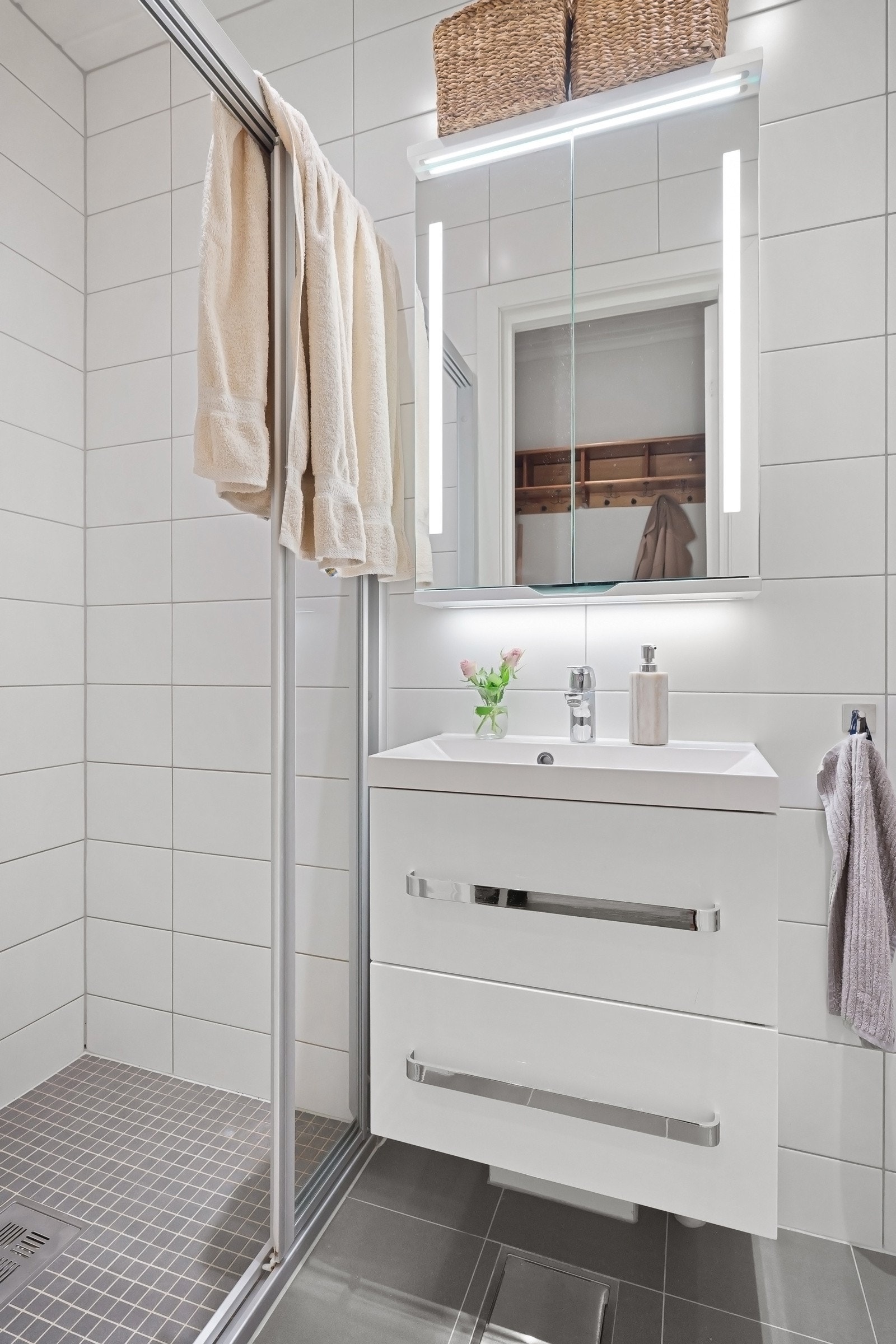 Lekker baderomsinnredning med servantskuffer og heldekkende servant. Speilskap over med integrert belysning. Galleribilde