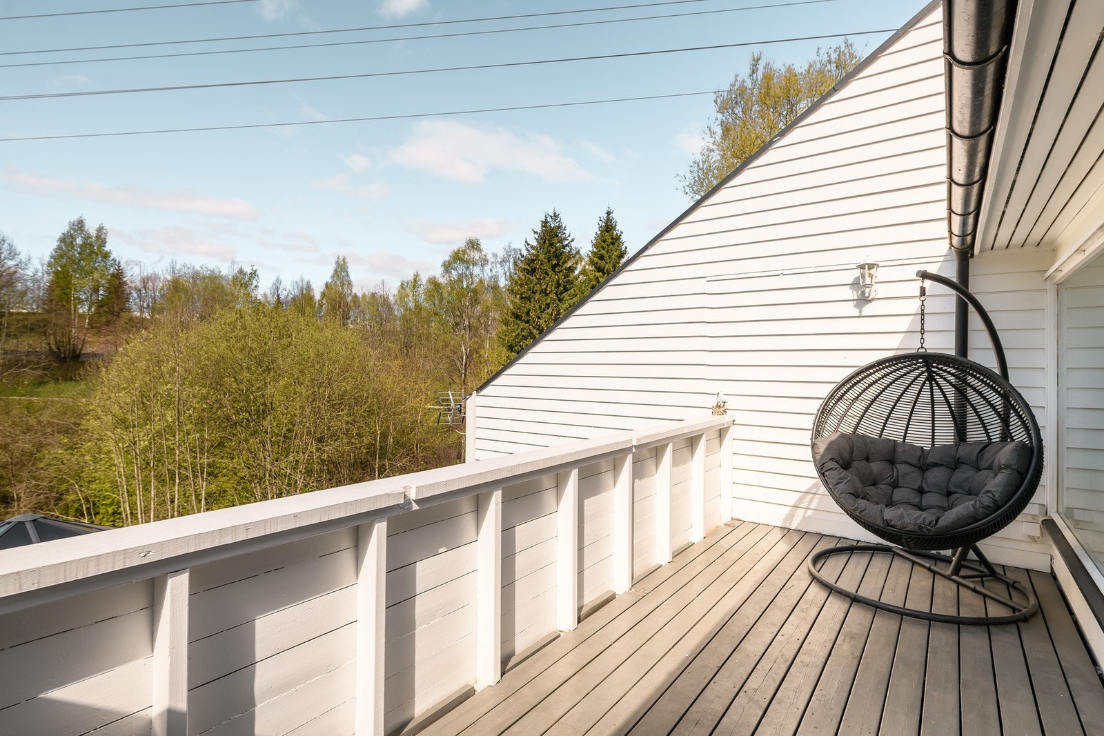 Fra stuen er det utgang til en vestvendt balkong med sen kveldssol og utsyn til skogsidyllen langs Alnaelva. Galleribilde