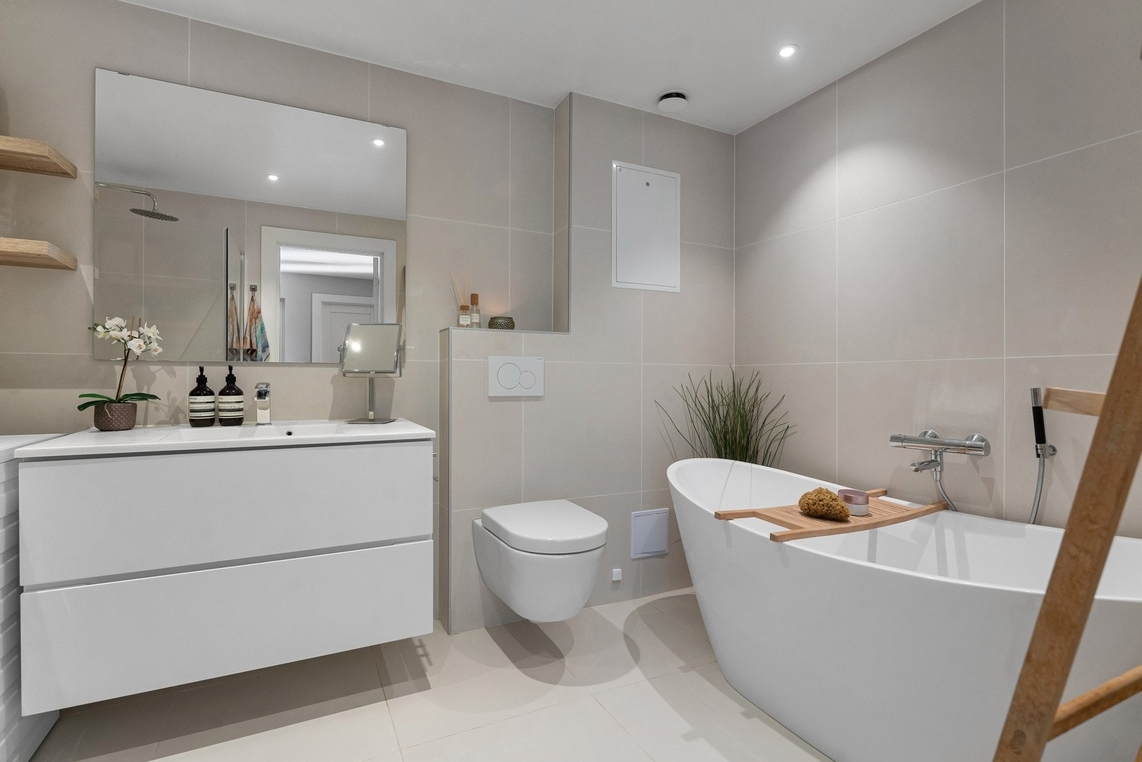 Delikat bad med fliser fra Modena. Innredning fra Kvik med servant med skuffer samt skjult stikkontakt i servantmøblet. Det er opplegg ved siden av servantmøbelen for vaskemaskin og tørketrommel. Galleribilde