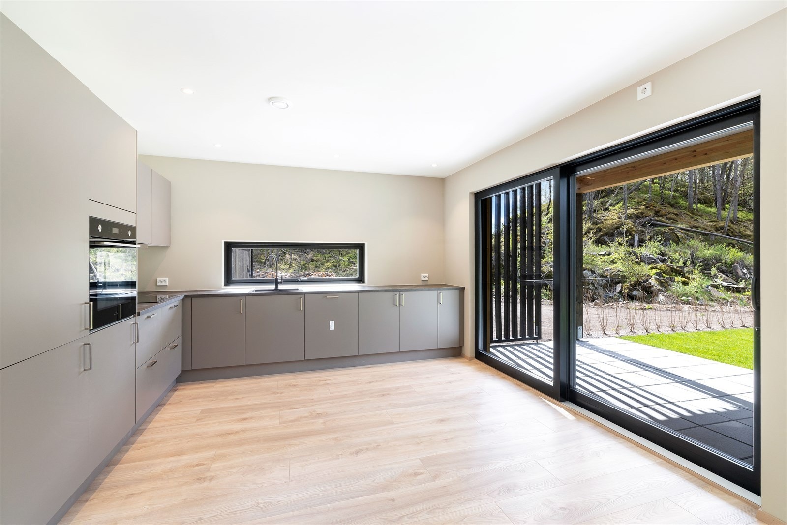 Det er vannbåren varme i gulv og de store vindusflatene i rommet sørger for rikelig med naturlig belysning Galleribilde