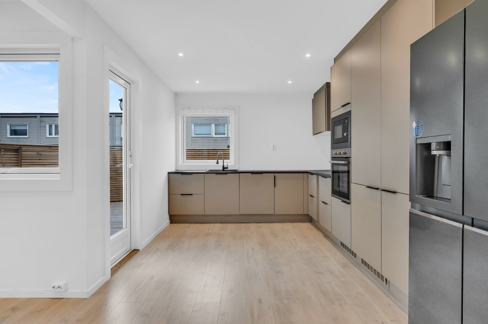 Hvitevarene består av frittstående kjøleskap med fryserdel og integrert oppvaskmaskin, komfyr og nedfelt induksjonstopp. Komfyrvakt er montert. Kjøkkenventilator med kullfilter over koketopp. Galleribilde