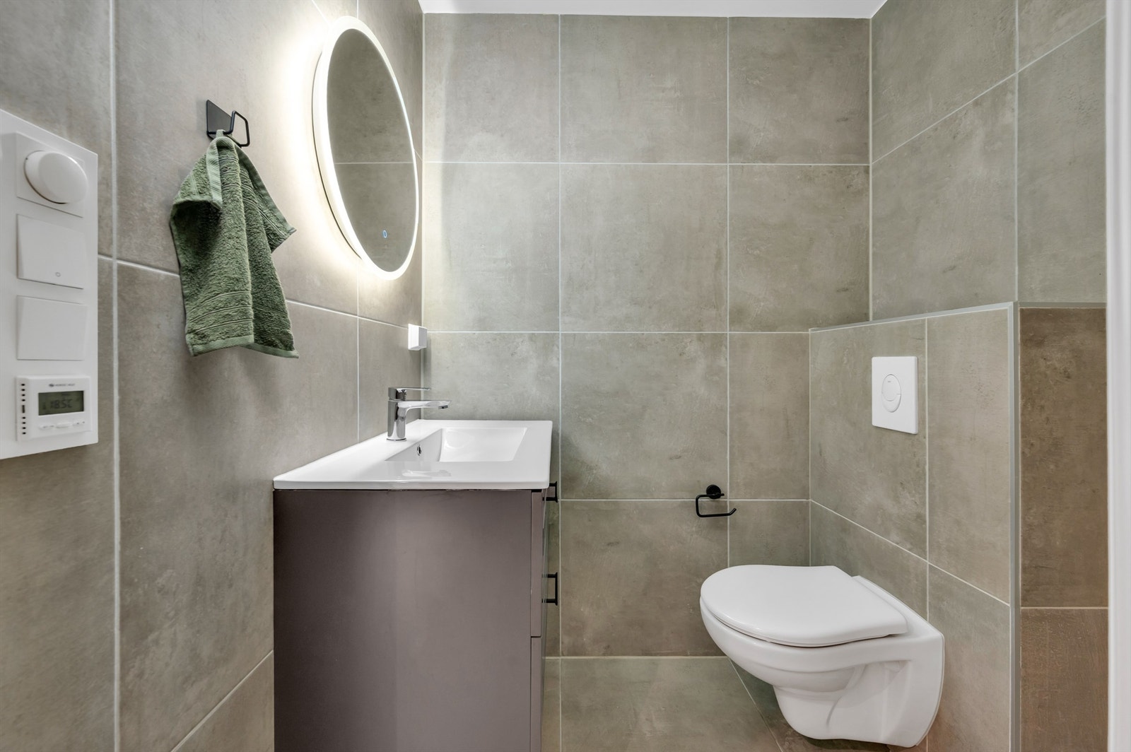 Innredningen består av vegghengt servantskap med heldekkende servant og ett-greps armatur, speilskap med overlys og stikkontakt over servant, dusjhjørne med innfellbare glassdører og dusjarmatur med hånddusj. Galleribilde