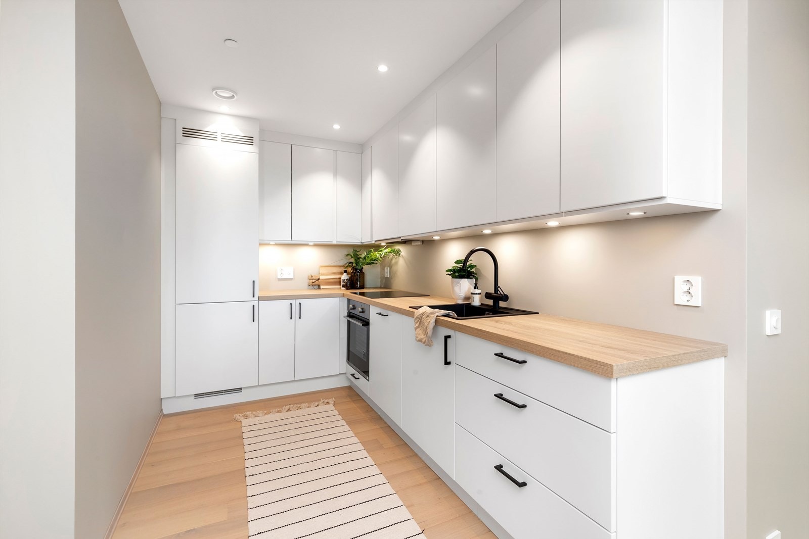 Kjøkkenet er praktisk plassert i rommet, med gode løsninger for oppbevaring Galleribilde