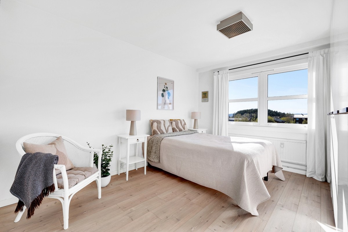 Soverommet har laminatgulv og malte flater på vegger og tak, noe som gir et nøytralt uttrykk og en lys atmosfære Galleribilde