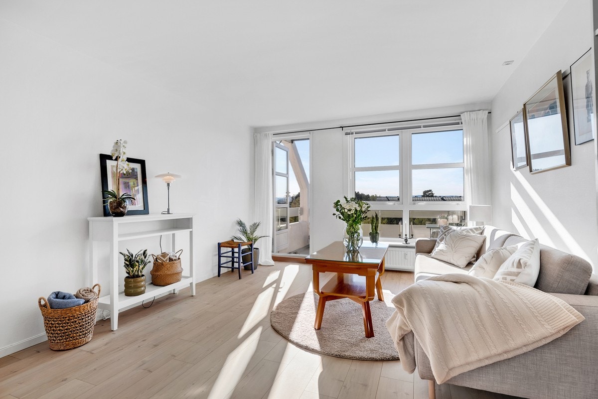 Store vindusflater sørger for naturlig lysinnslipp og skaper et lyst og funksjonelt oppholdsrom Galleribilde