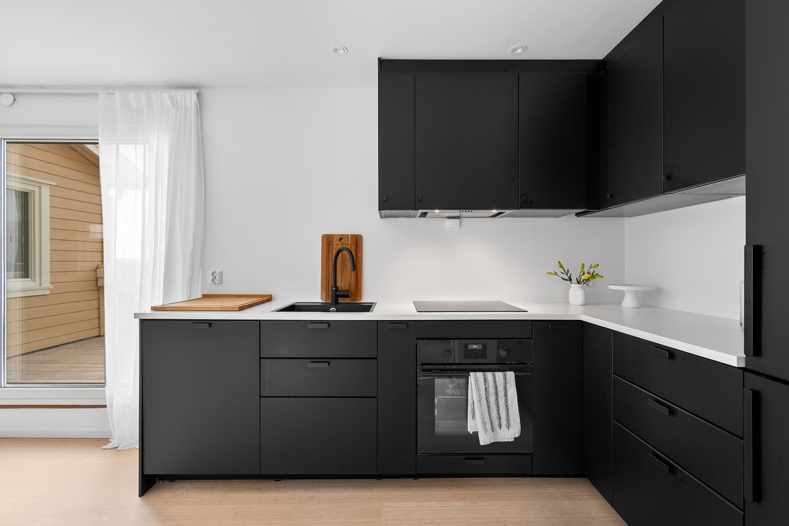 Lekkert Ikea kjøkken av type Kungsbacka fra 2017. Lys benkeplate og svart nedfeldt vask. Galleribilde