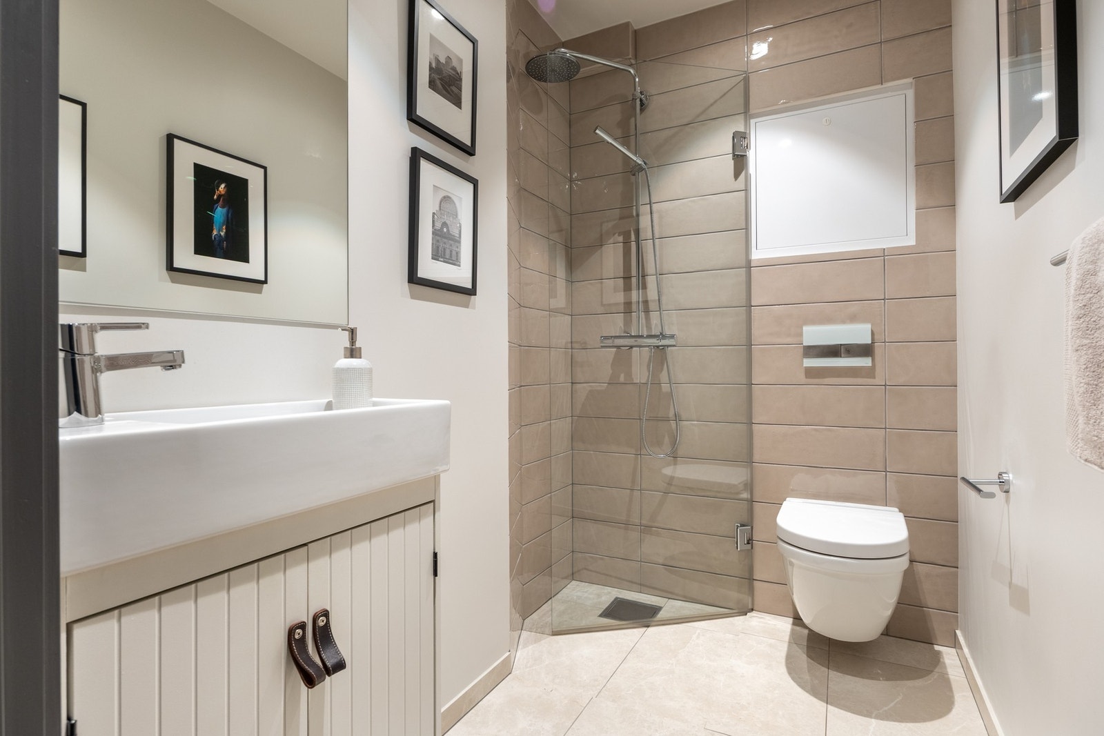 Det andre badet er innredet med de samme, lyse gulvflisene og dusjnisje med harmonerende veggfliser. De øvrige veggene er hvitmalte, det er downlights i himling og varme i gulv. Galleribilde