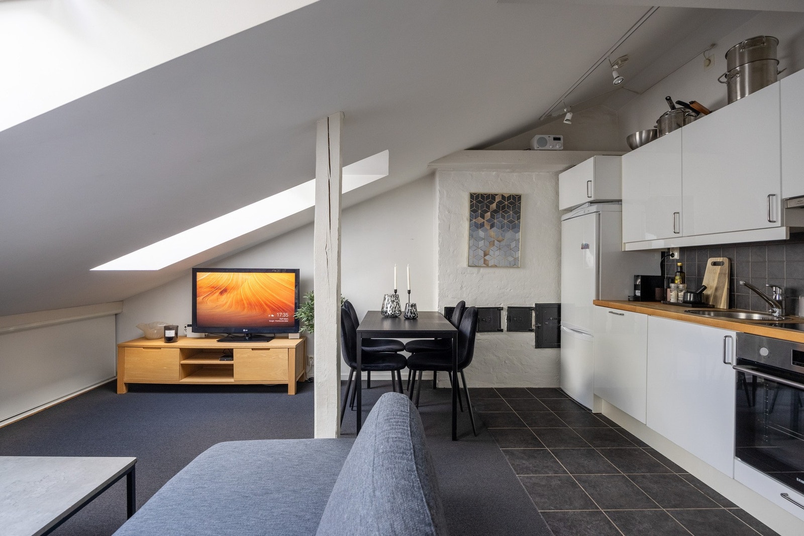 Kjøkkenet har hvite, glatte fronter og benkeplate i heltre med nedfelt vaskekum. Stekeovn, koketopp og oppvaskmaskin er integrert, og det er ventilator over kokesonen. Galleribilde