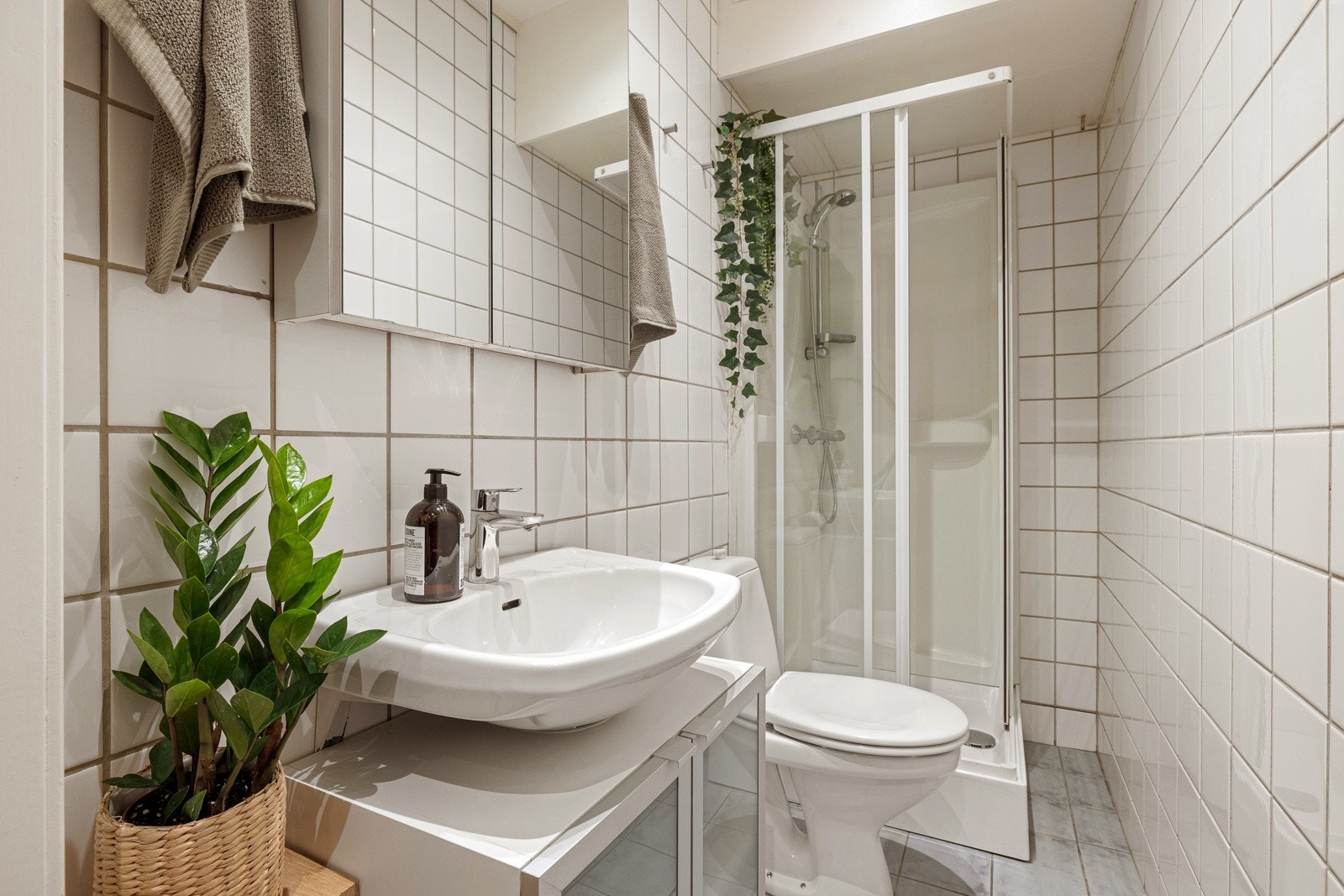 Flislagte gulv med gulvvarme, flislagte vegger og nedsenket himling med takplater og downlights. Galleribilde