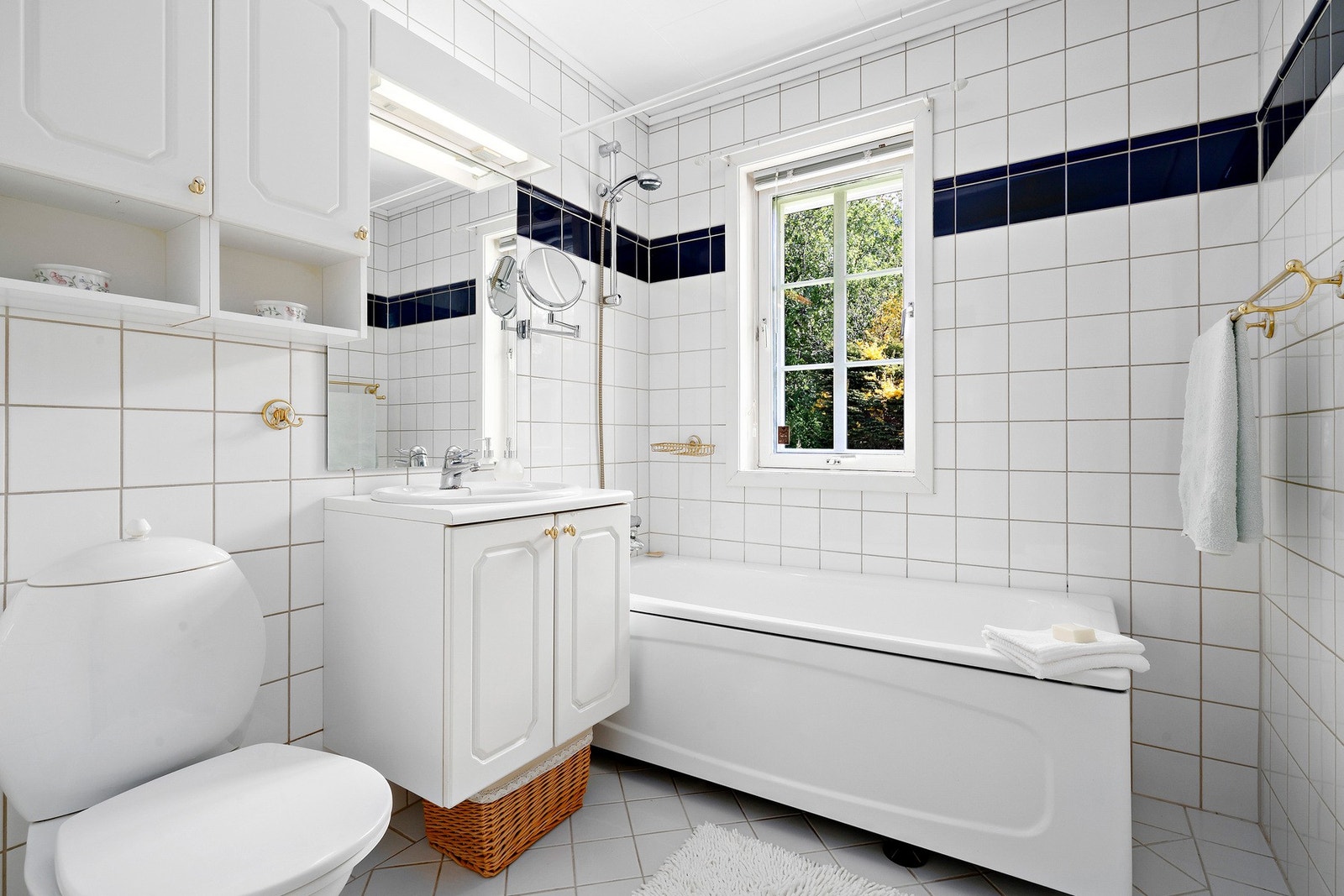 Det flislagte badet i 1.etg har gulvstående toalett, baderomsinnredning med speil og belysning. Frittstående badekar. Galleribilde