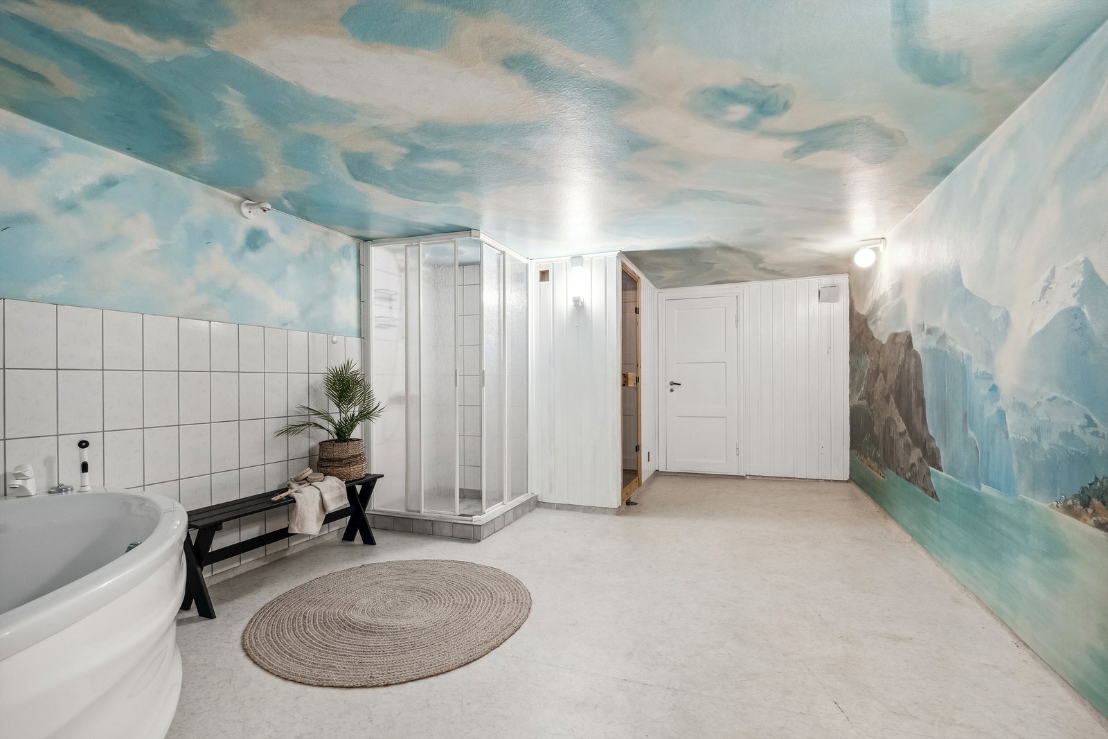 Bad som har belegg på gulvet, samt en kombinasjon av fliser, malt strie og panel på veggene. Utstyrt med dusjvegger og boblekar. Galleribilde