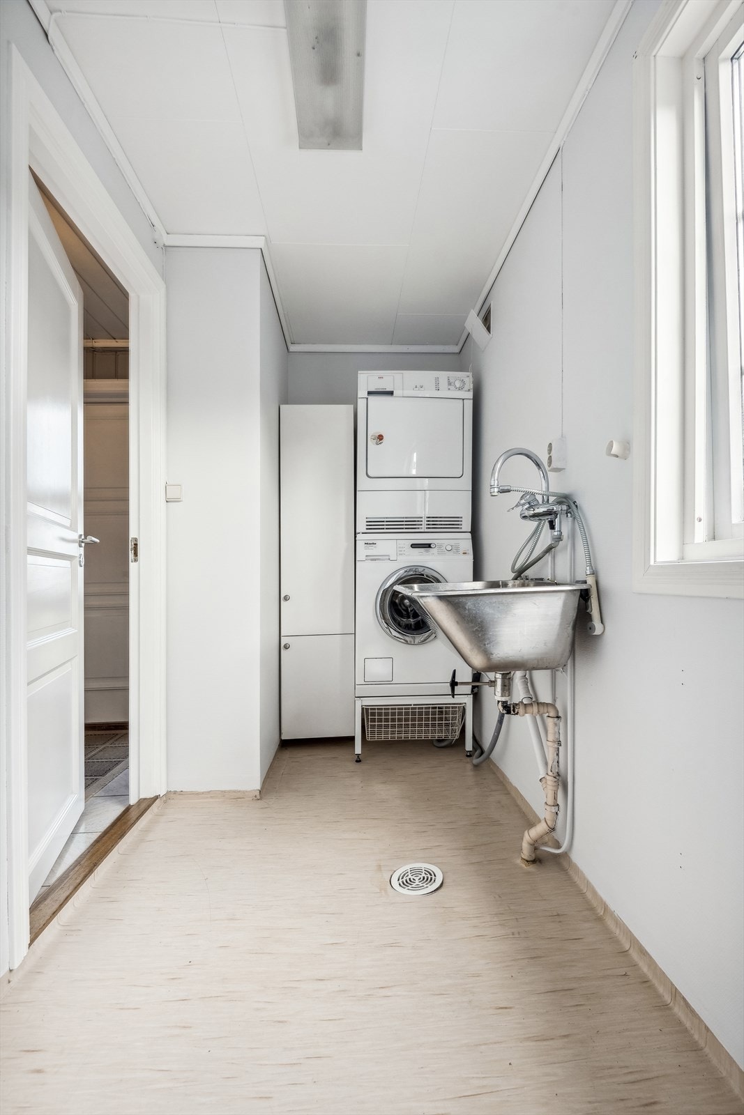 Vaskerommet i 1. etasje. Det har gulvbelegg, vegger med malt strie, og himlingsplater i taket. Utstyrt med en utslagsvask og opplegg for vaskemaskin. Galleribilde