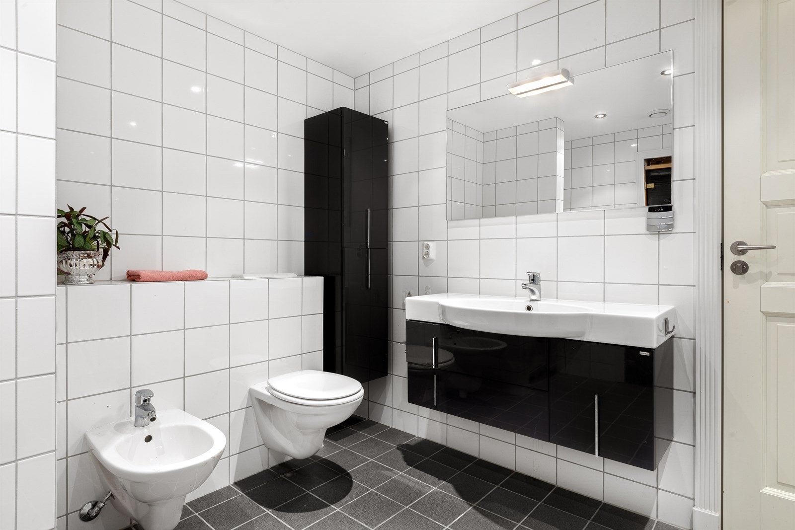 Servantinnredning med tilhørende speil, samt høyskap. Elektriske varmekabler i gulv og downlights i tak. Galleribilde