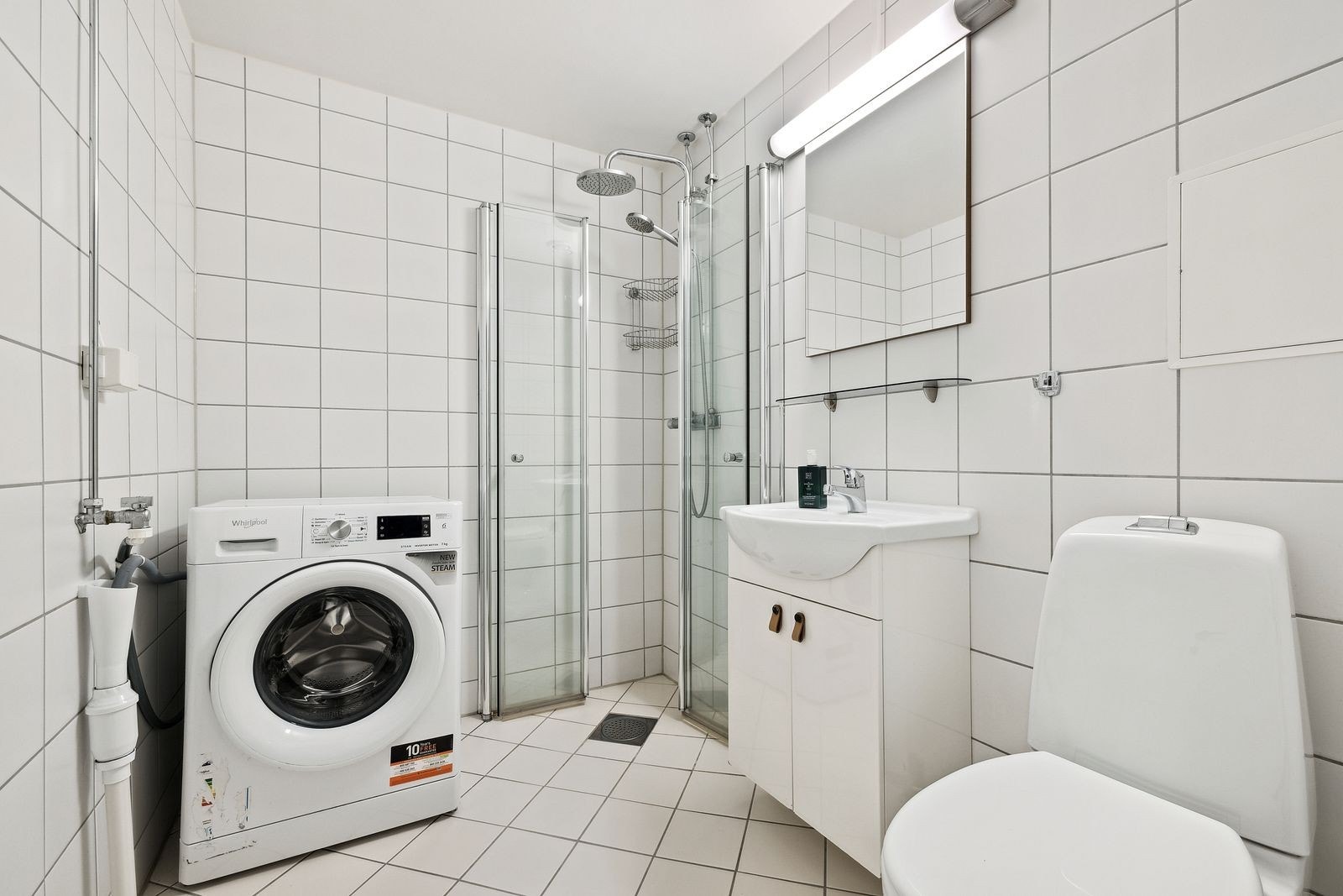 Pent flislagt bad med varme i gulv og vaskemaskin. Galleribilde