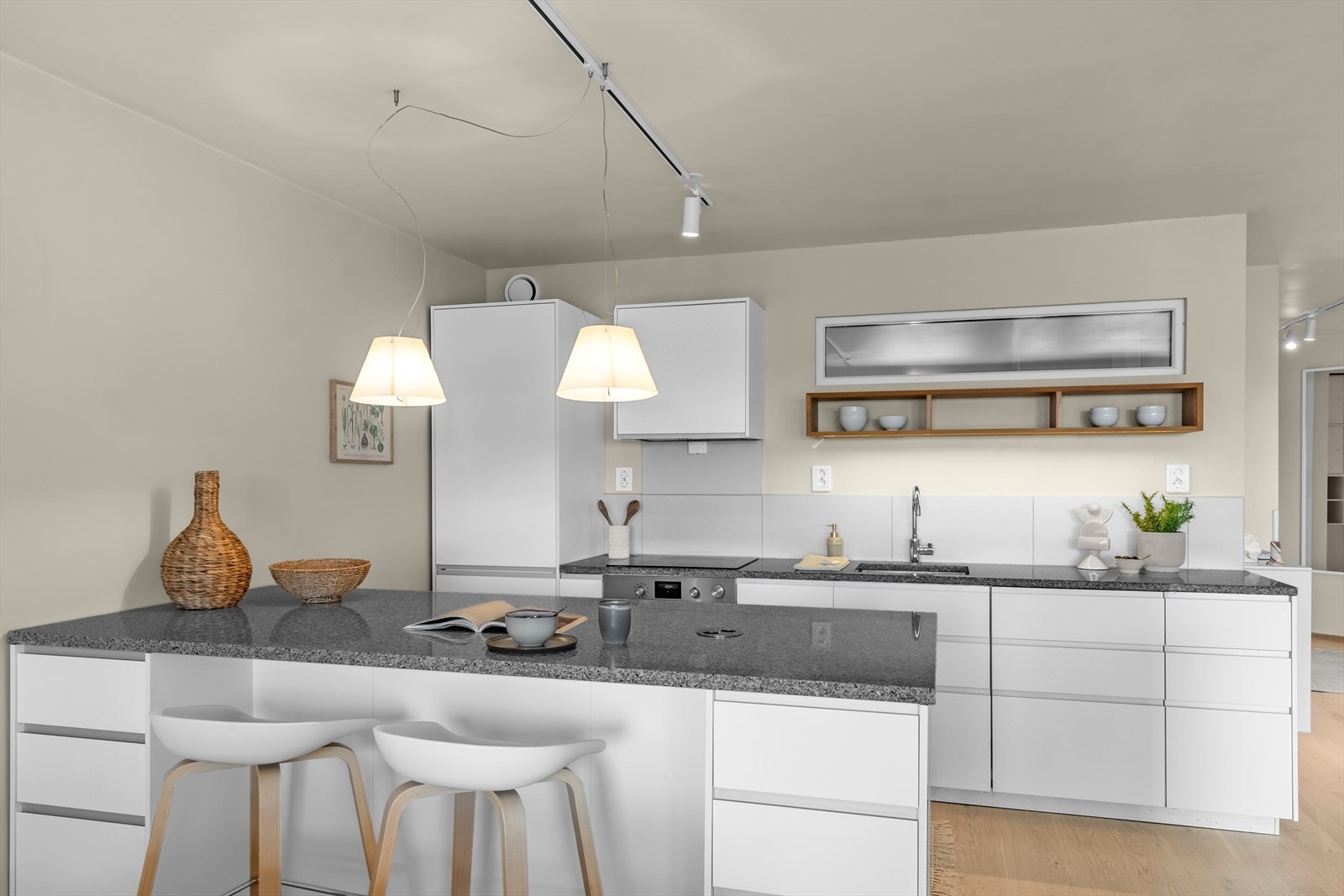 Kjøkkenet er påkostet med en elegant steinplate på overbenk, god plass i underskap og integrerte hvitevarer. Galleribilde