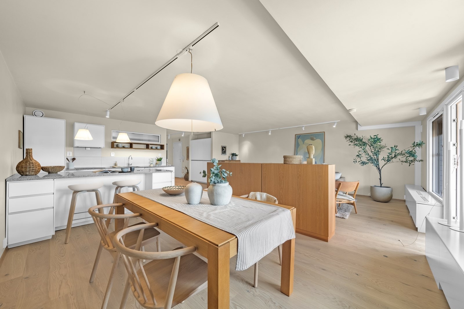 Den åpne løsningen mot kjøkkenet gir en sosial og romslig følelse, perfekt for både hverdagsliv og underholdning. Galleribilde