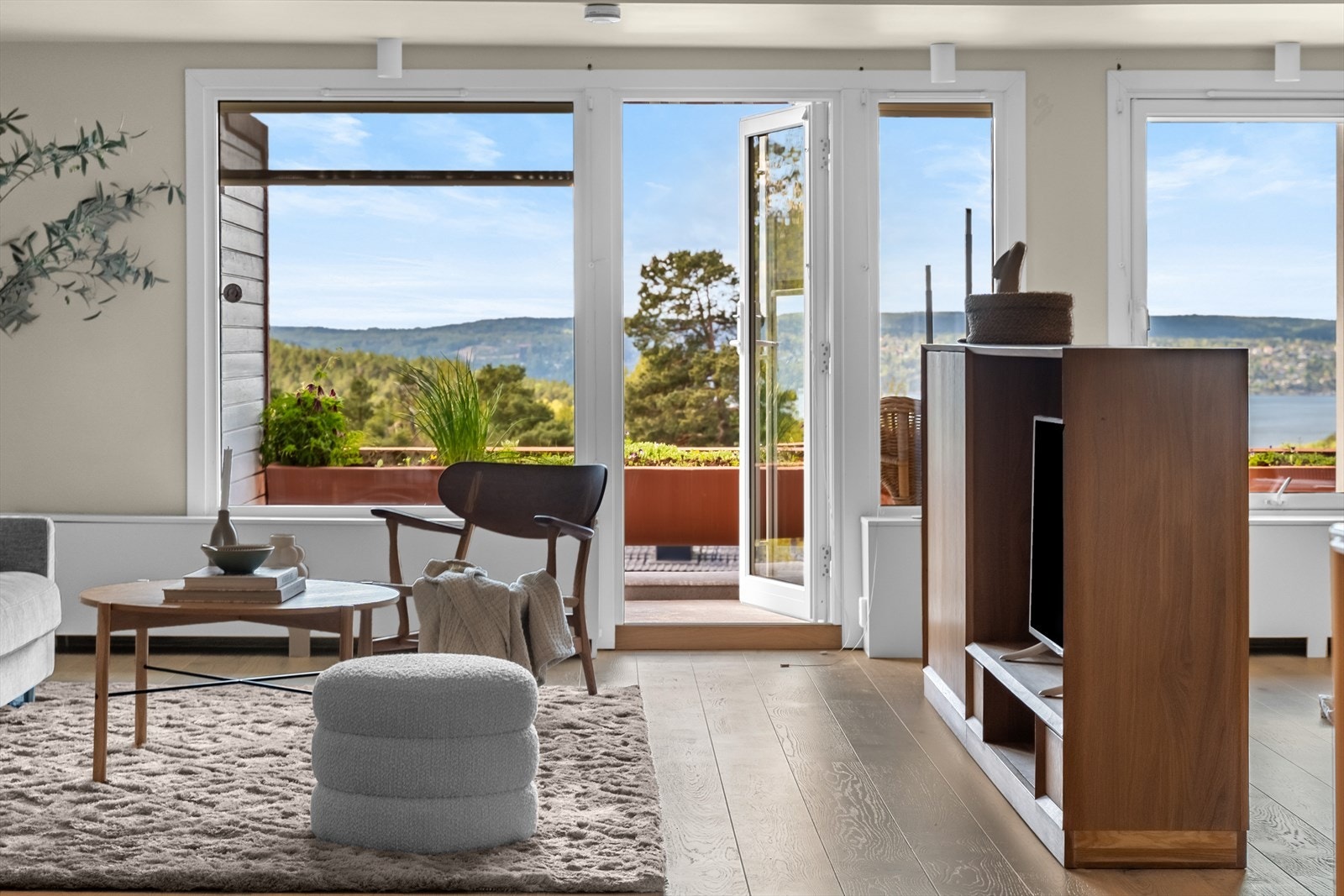 Innbydende stue med store vindusflater som gir rikelig med naturlig lys og en fantastisk utsikt mot fjorden. Galleribilde