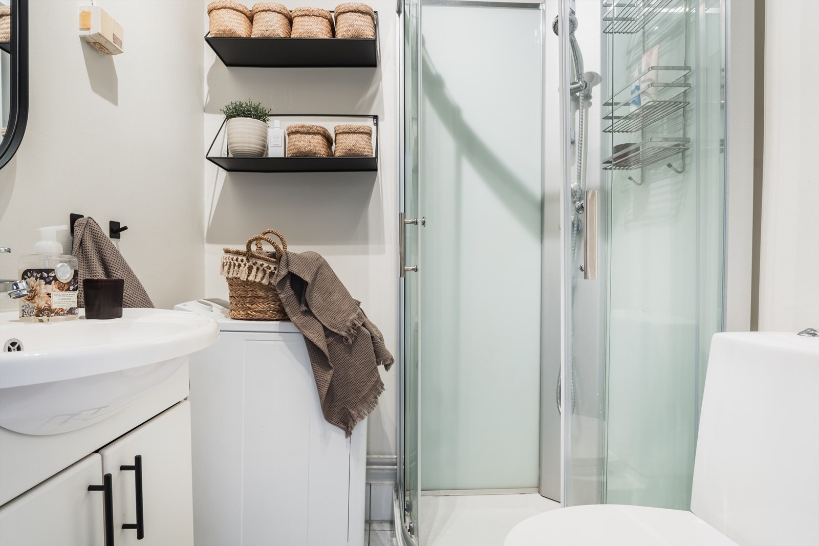 Bad med dusjkabinett, skapinnredning med nedfelt servant og gulvmontert toalett. Opplegg for vaskemaskin. Galleribilde