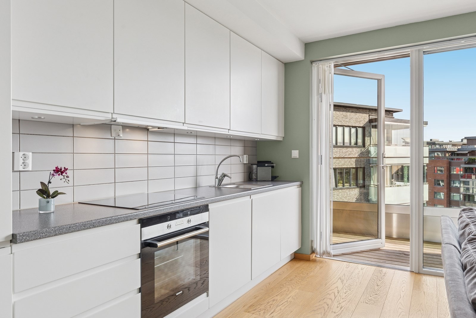 Kjøkkenet har en stilren og lekker utførelse med slette, hvite fronter. Galleribilde